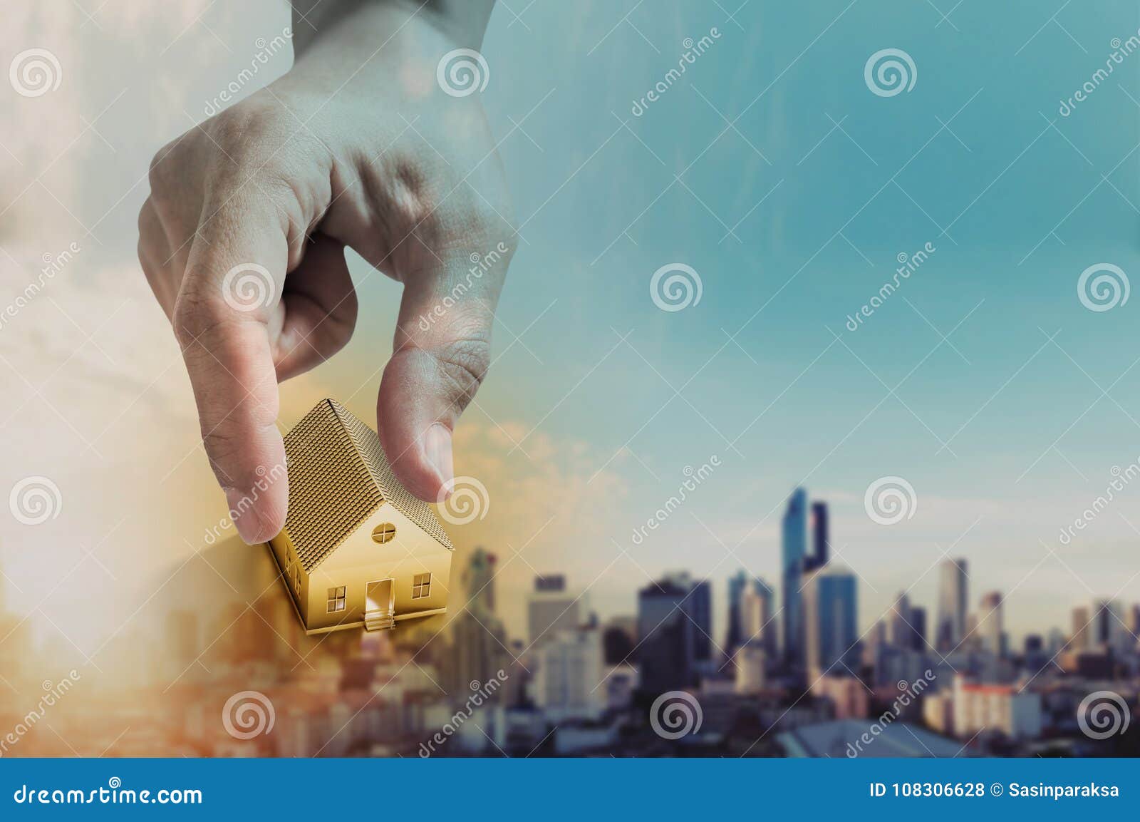 hand holding golden house, real estate investment and buying house concept, defocus city in sunrise background
