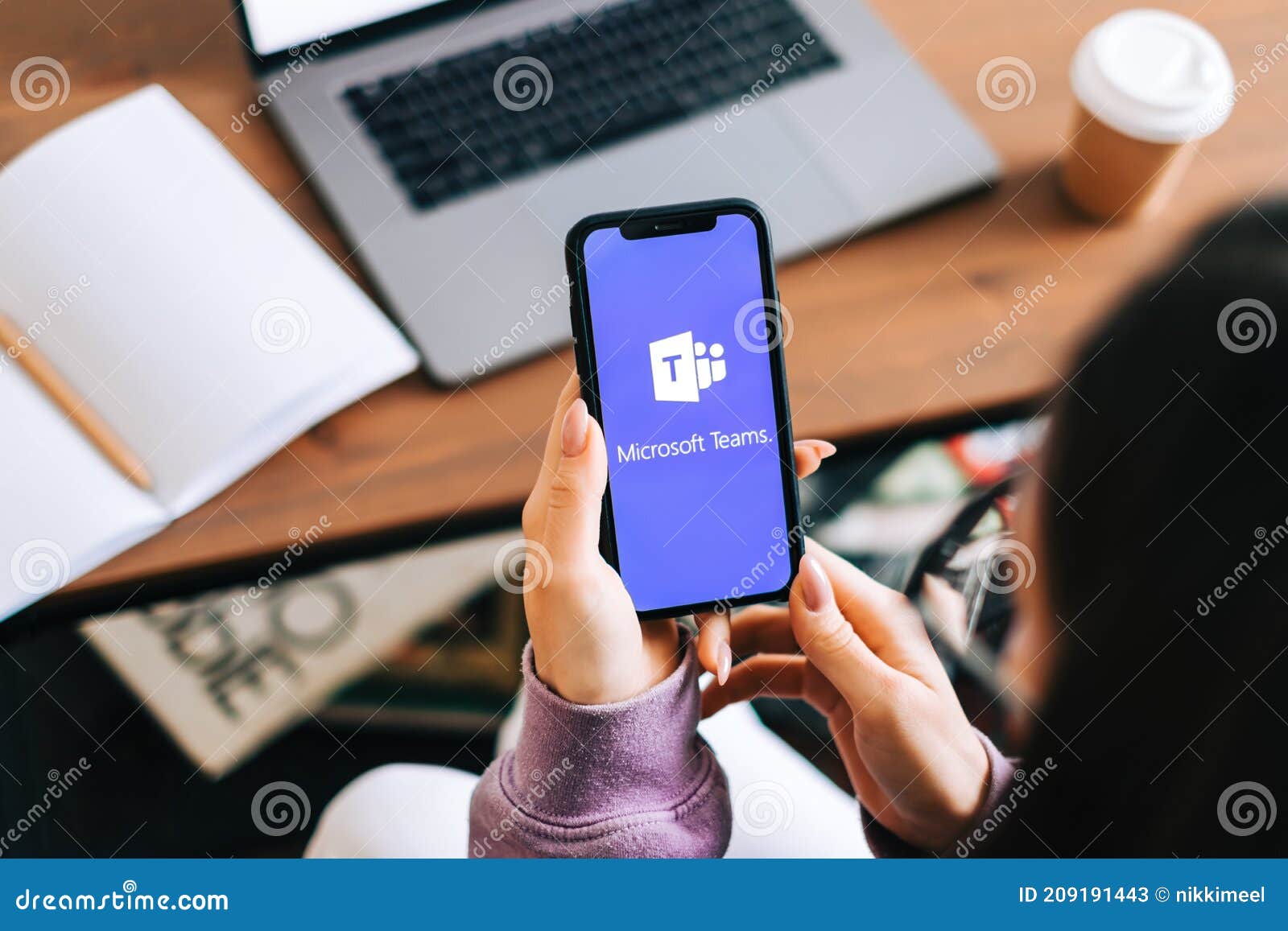 Hand Holding IPhone with Microsoft Teams Video Call App Logo on the