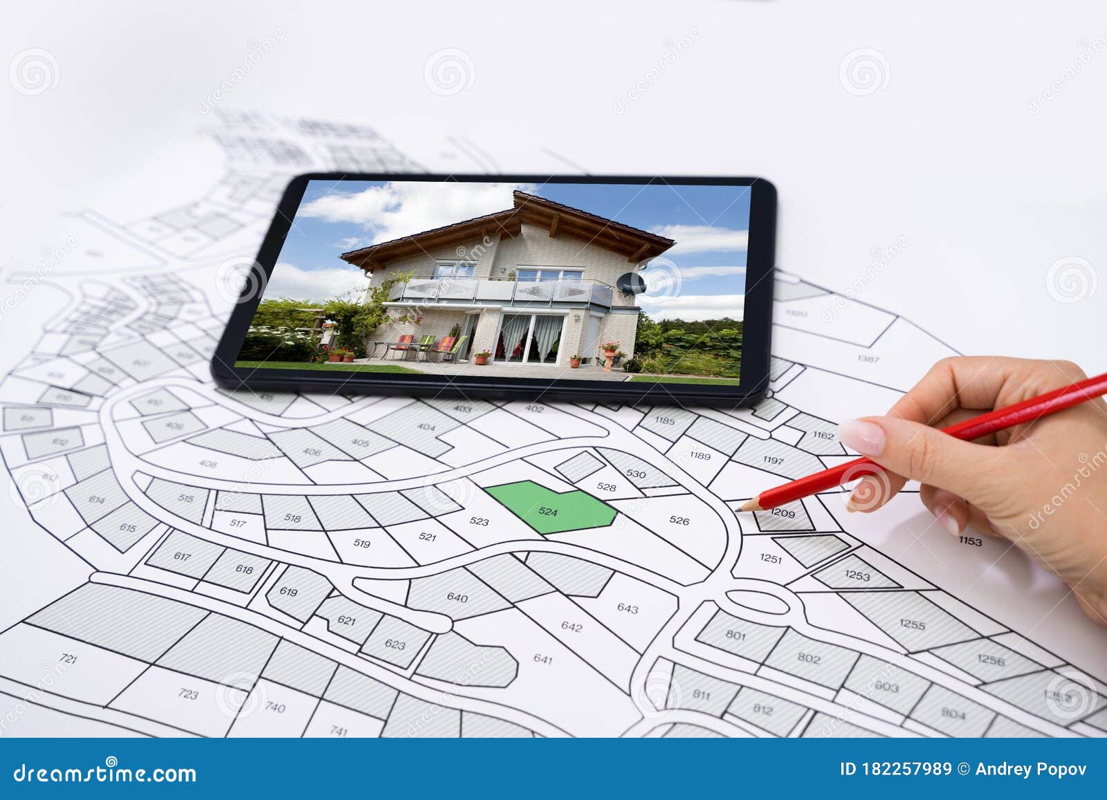 hand holding pencil over cadastre map new tablet
