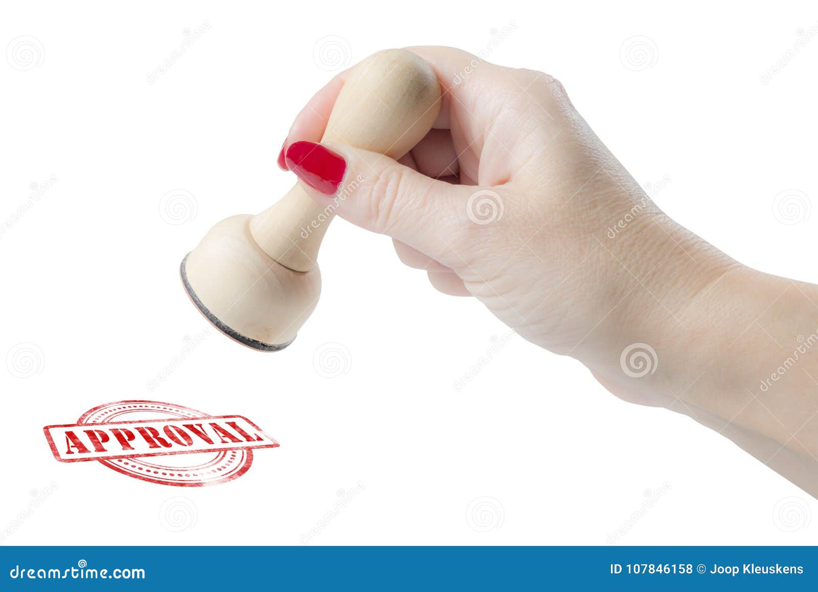 hand holding a rubber stamp with the word approval