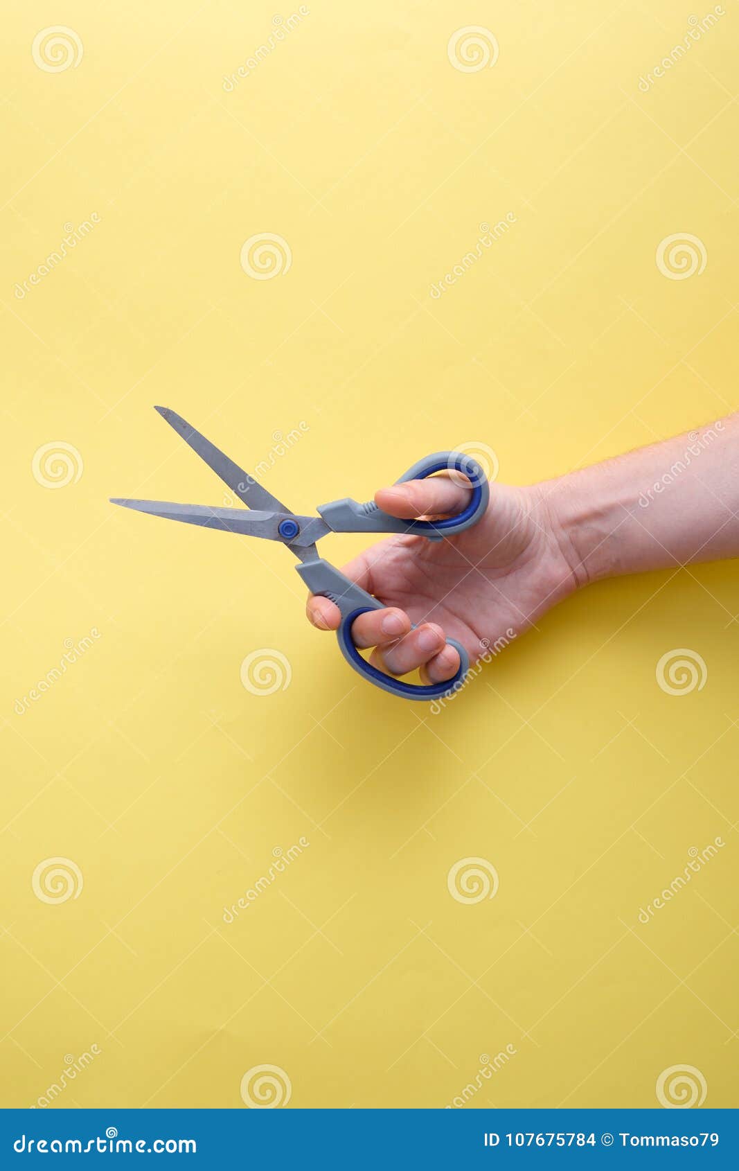 Hand Holding Scissors on Yellow Background Stock Photo - Image of ...