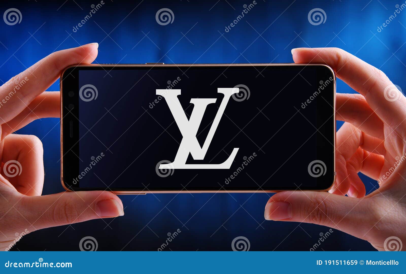 Hand Holding Smartphone Displaying Logo of Louis Vuitton Editorial