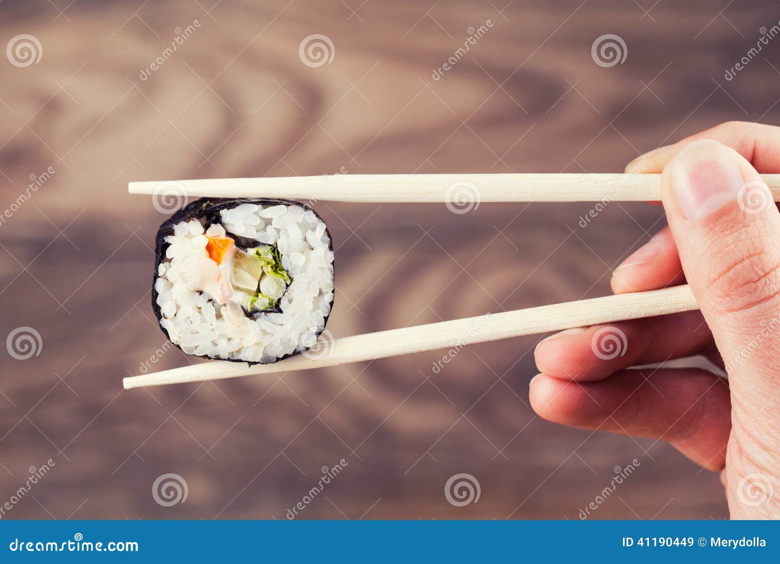 Hand Holding Sushi Roll Using Chopsticks Stock Image Image of