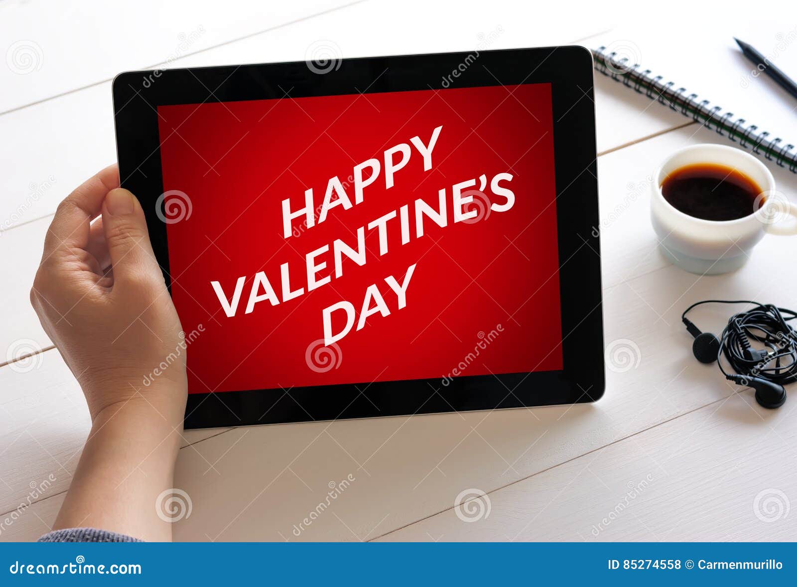 hand holding tablet computer with valentine`s day concept on scr