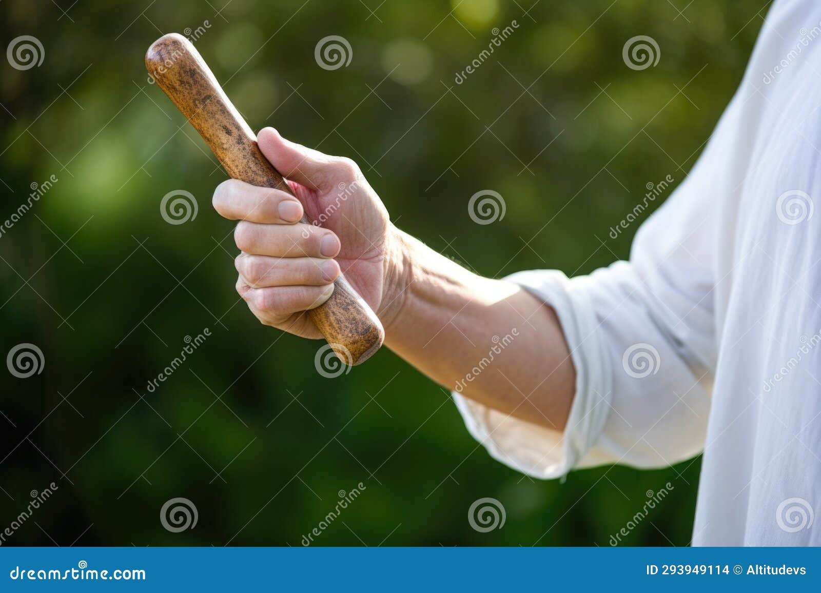 hand holding up a qi gong wand