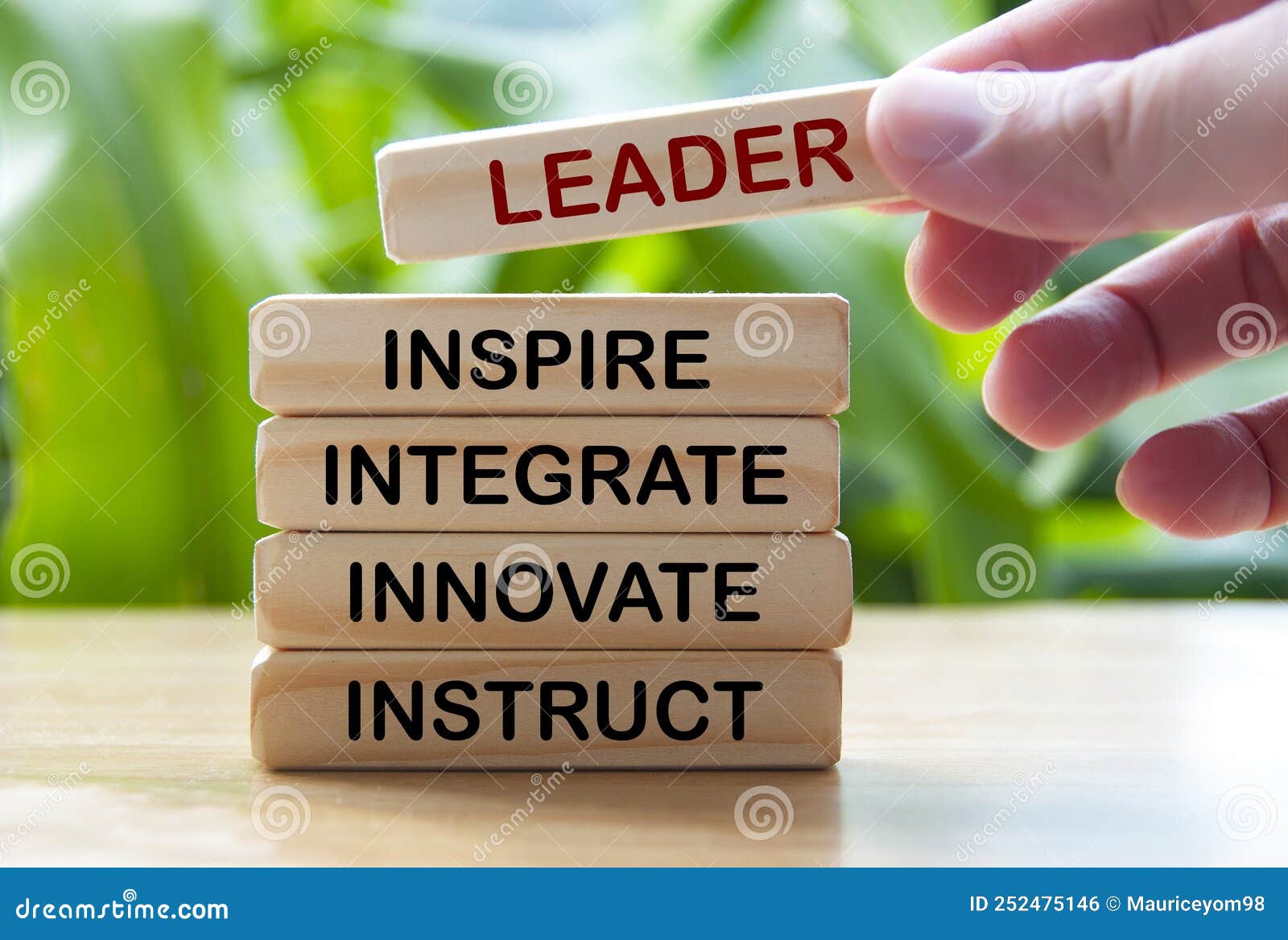 hand holding wooden blocks with text - leader, inspire, integrate, innovate, instruct.