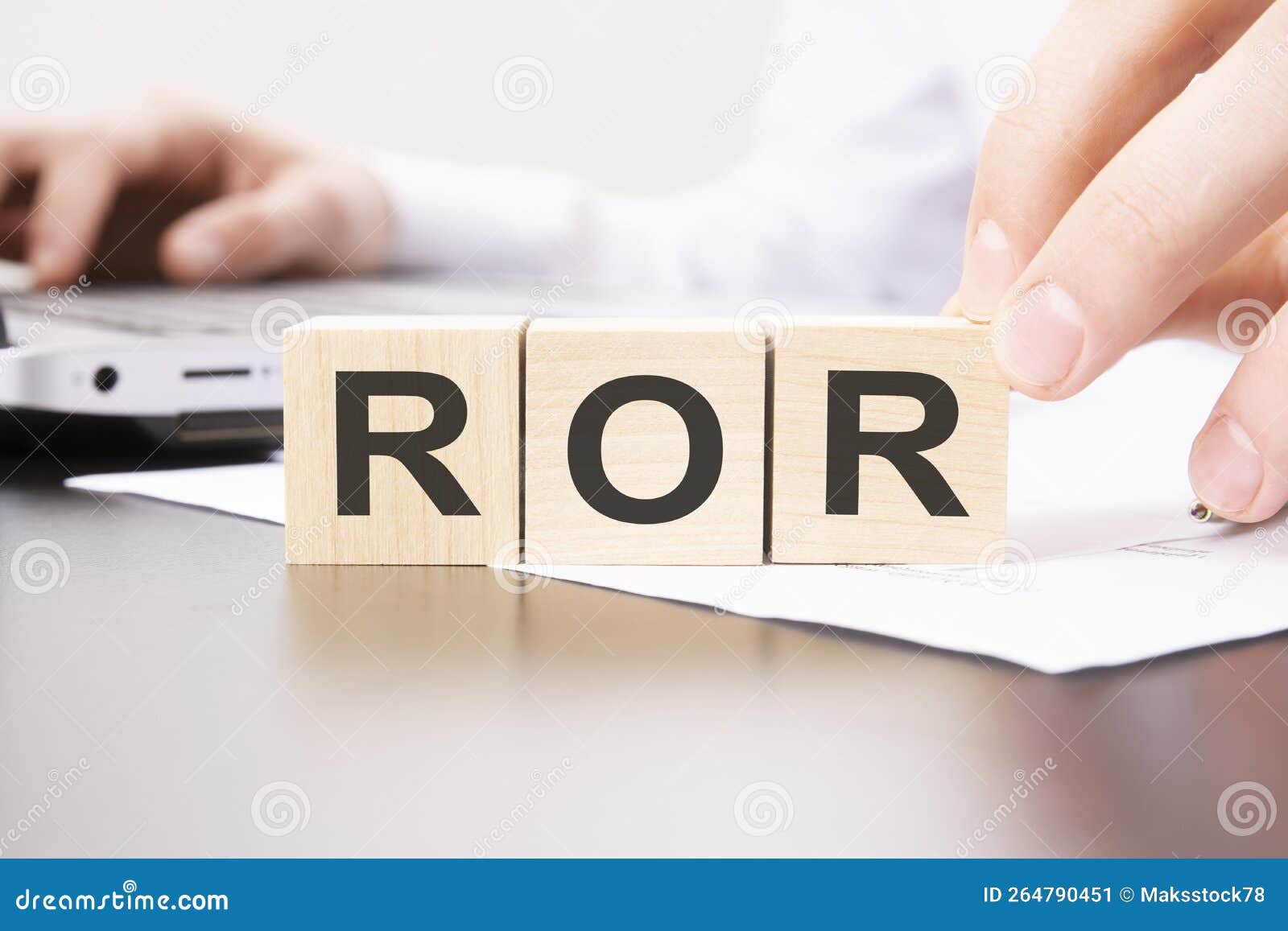 hand holding wooden cube with ror text on table background. financial, marketing and business 