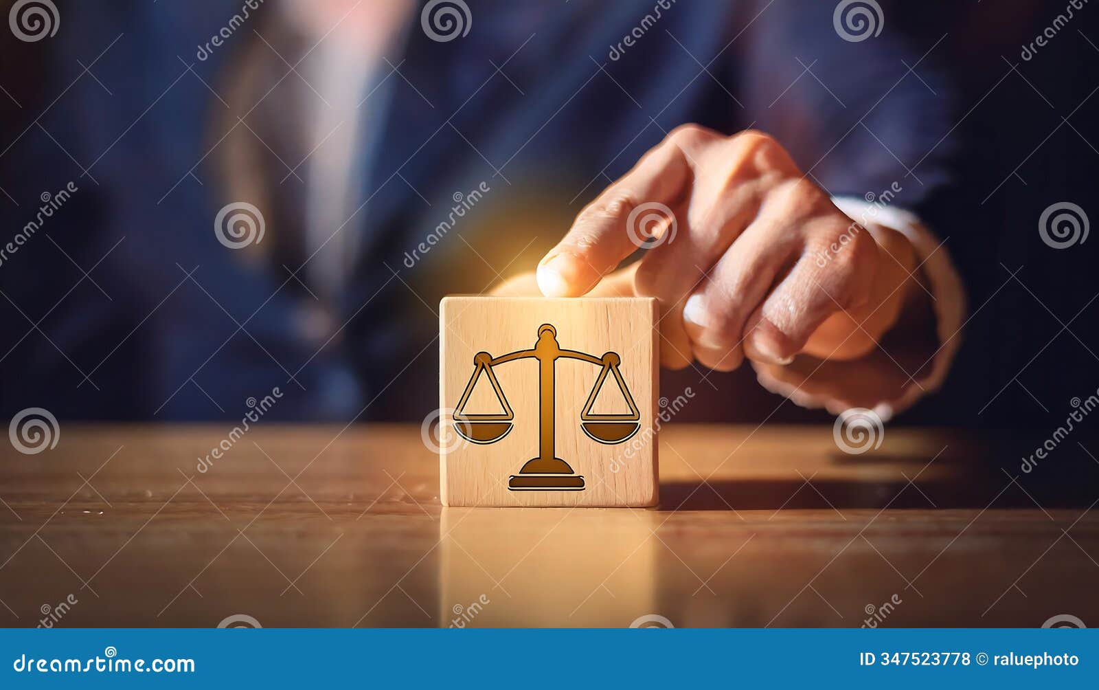 a hand holds a wooden block with a black scale of justice , representing law and fairness