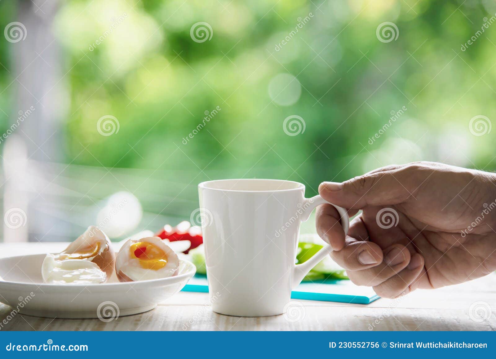 hand hooding hot coffee cup with boiled eggs