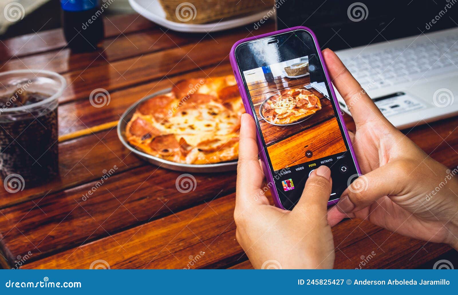 hand of person with mobile photographing food to publish on networks