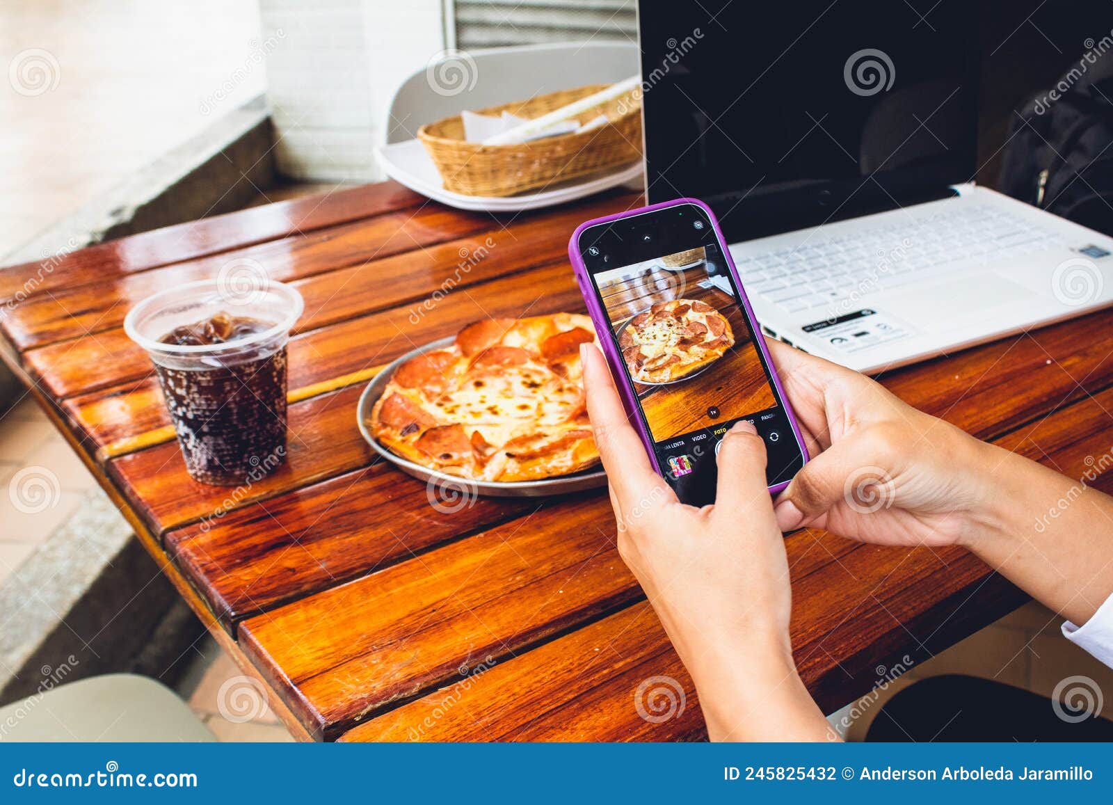 hand of person with mobile photographing food to publish on networks