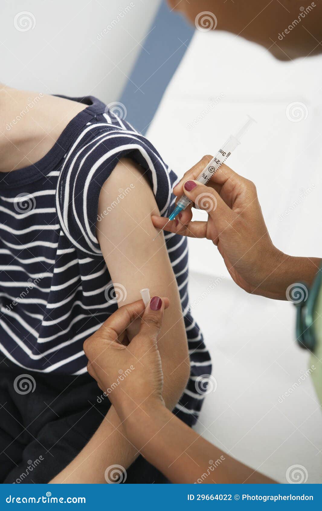 hand injecting vaccine on boy's arm