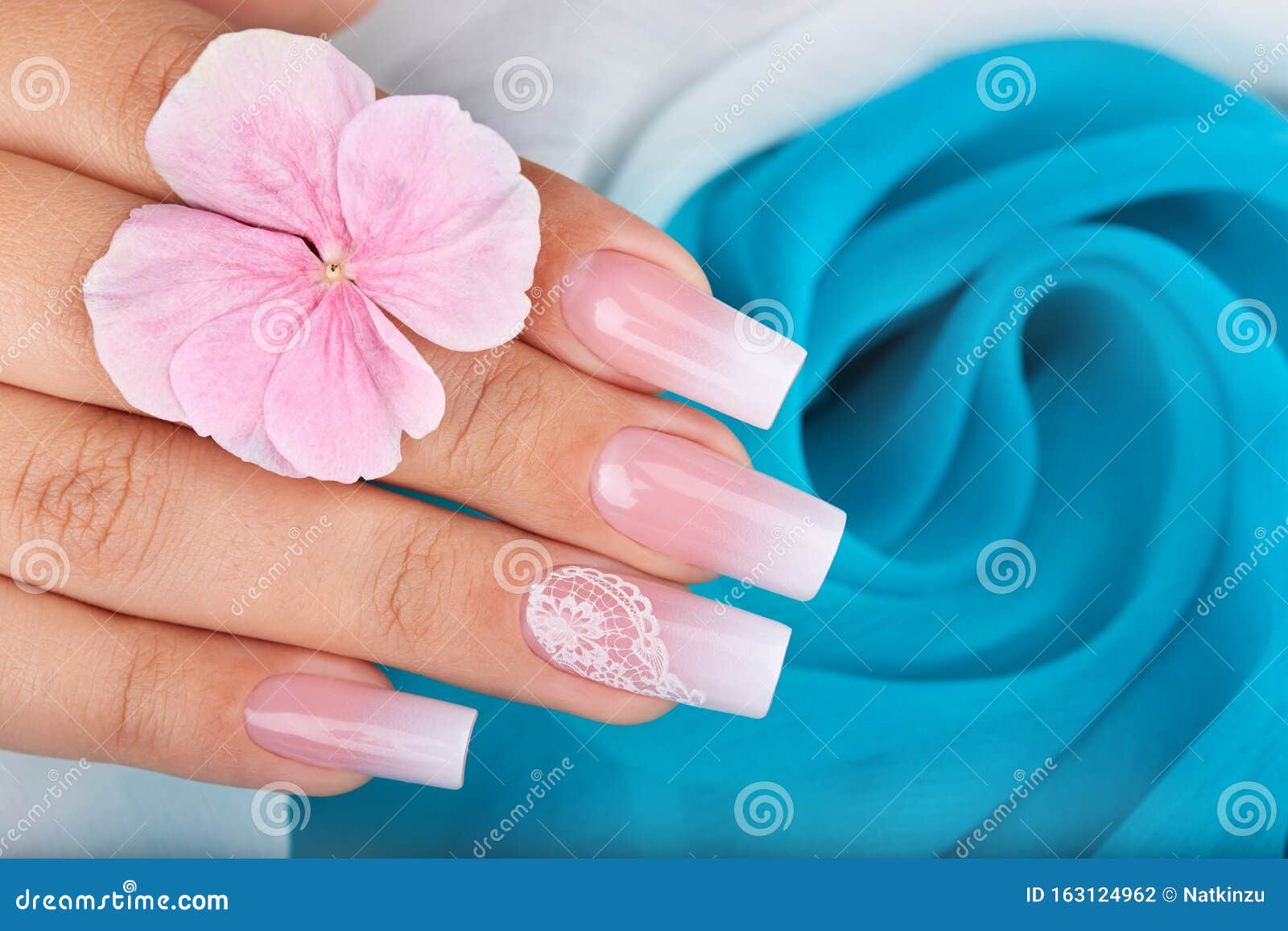 hand with long artificial manicured nails with ombre gradient 