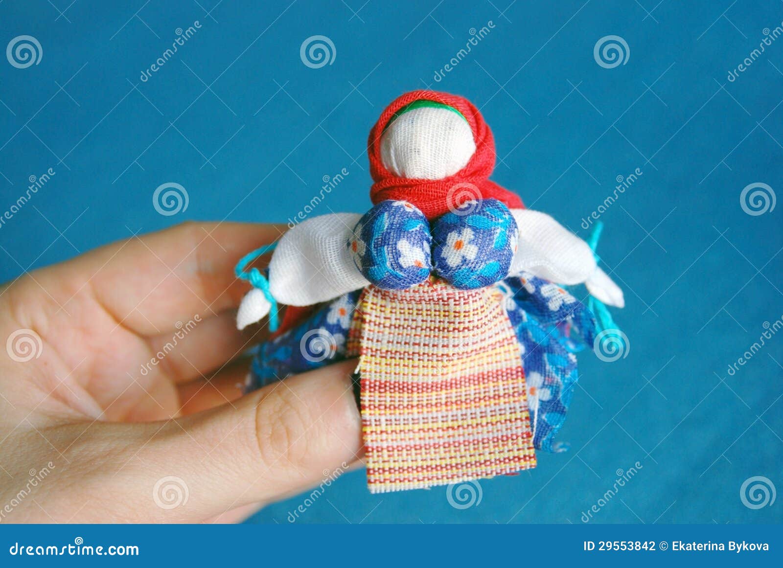 hand-made colorful doll on blue background