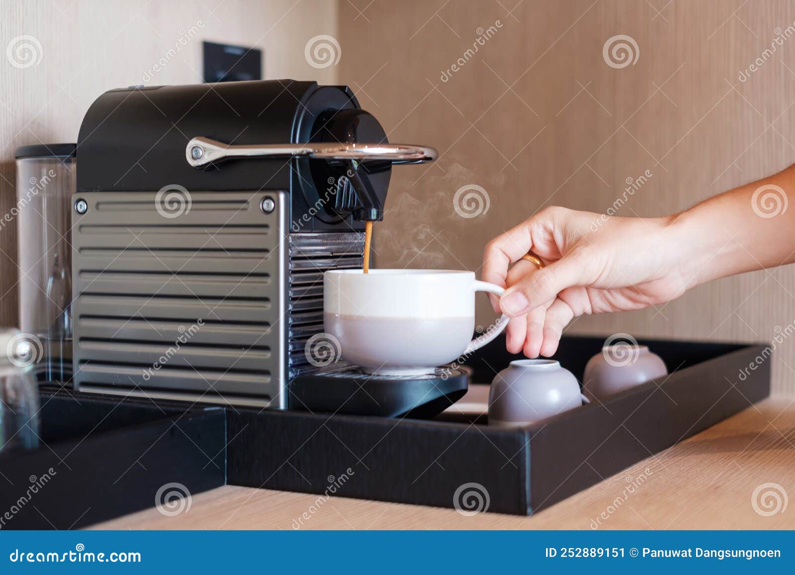Hand Making Espresso by Coffee Machine with Capsules on Wood Table