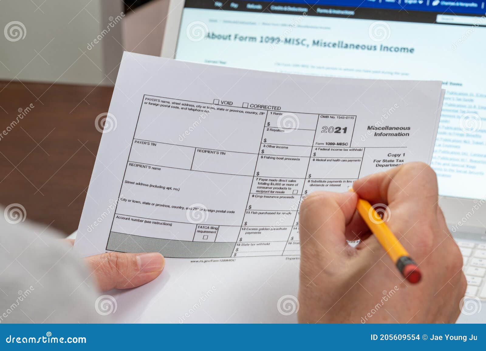 the hand of the man holding the tax form 1099-misc