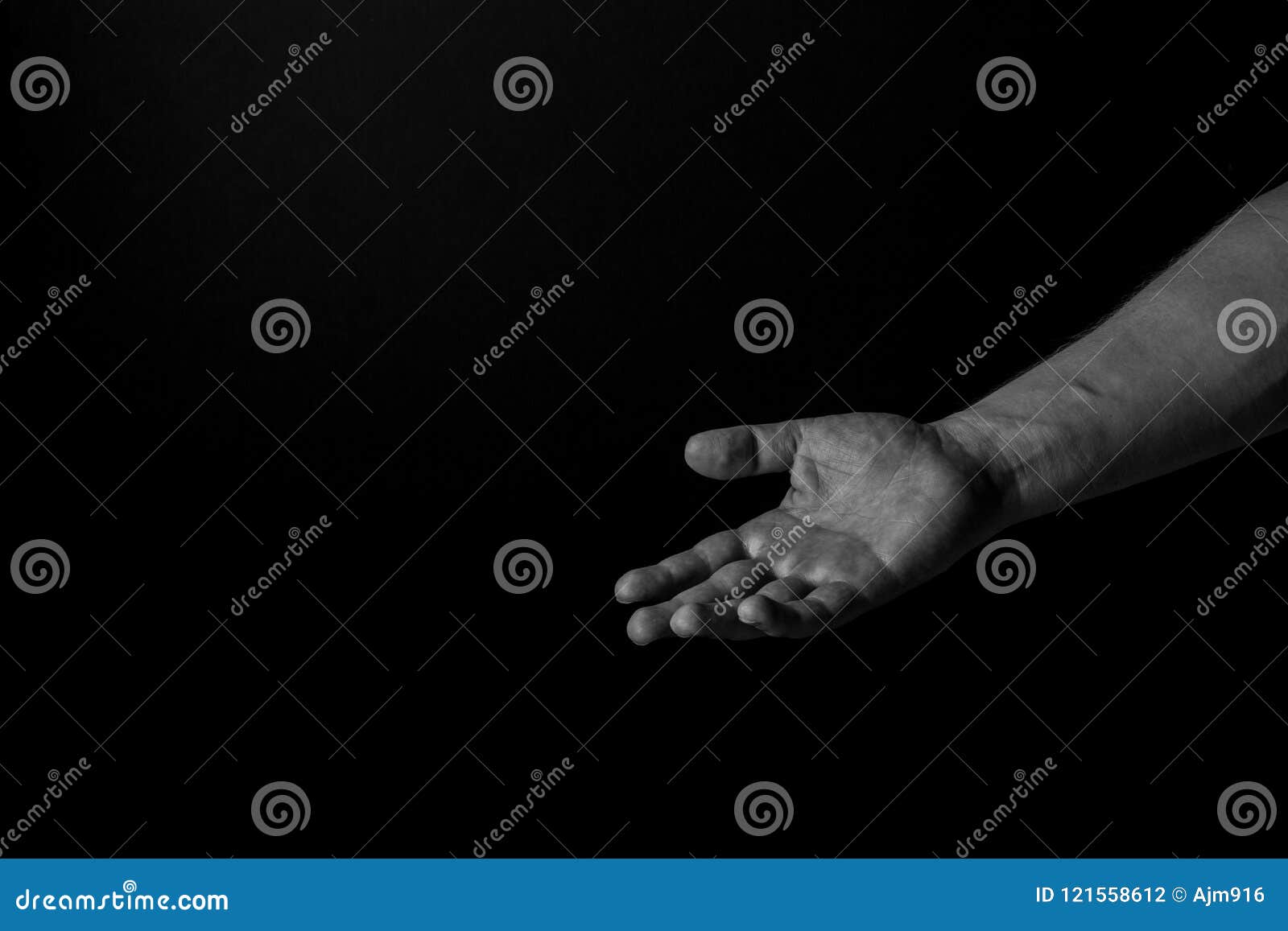 hand of a man palm up reaching, on black background, giving a helping hand. give me your hand concept.