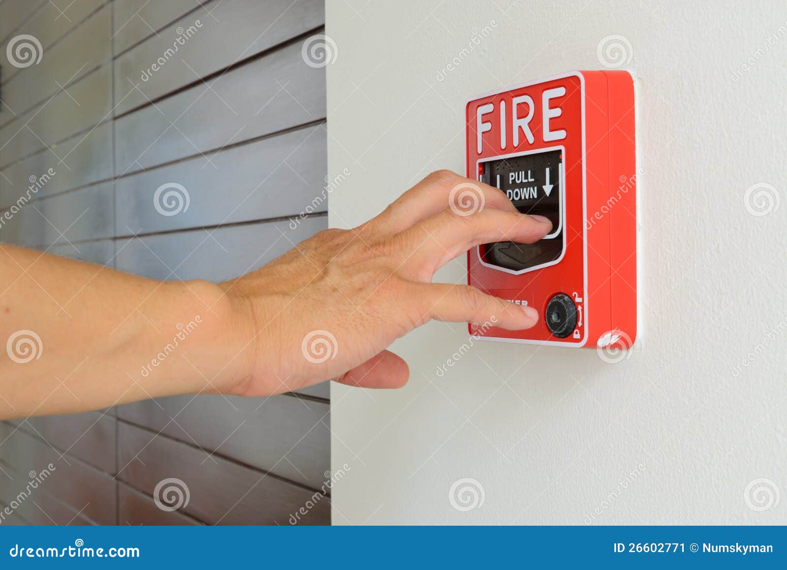 the hand of man is pulling fire alarm
