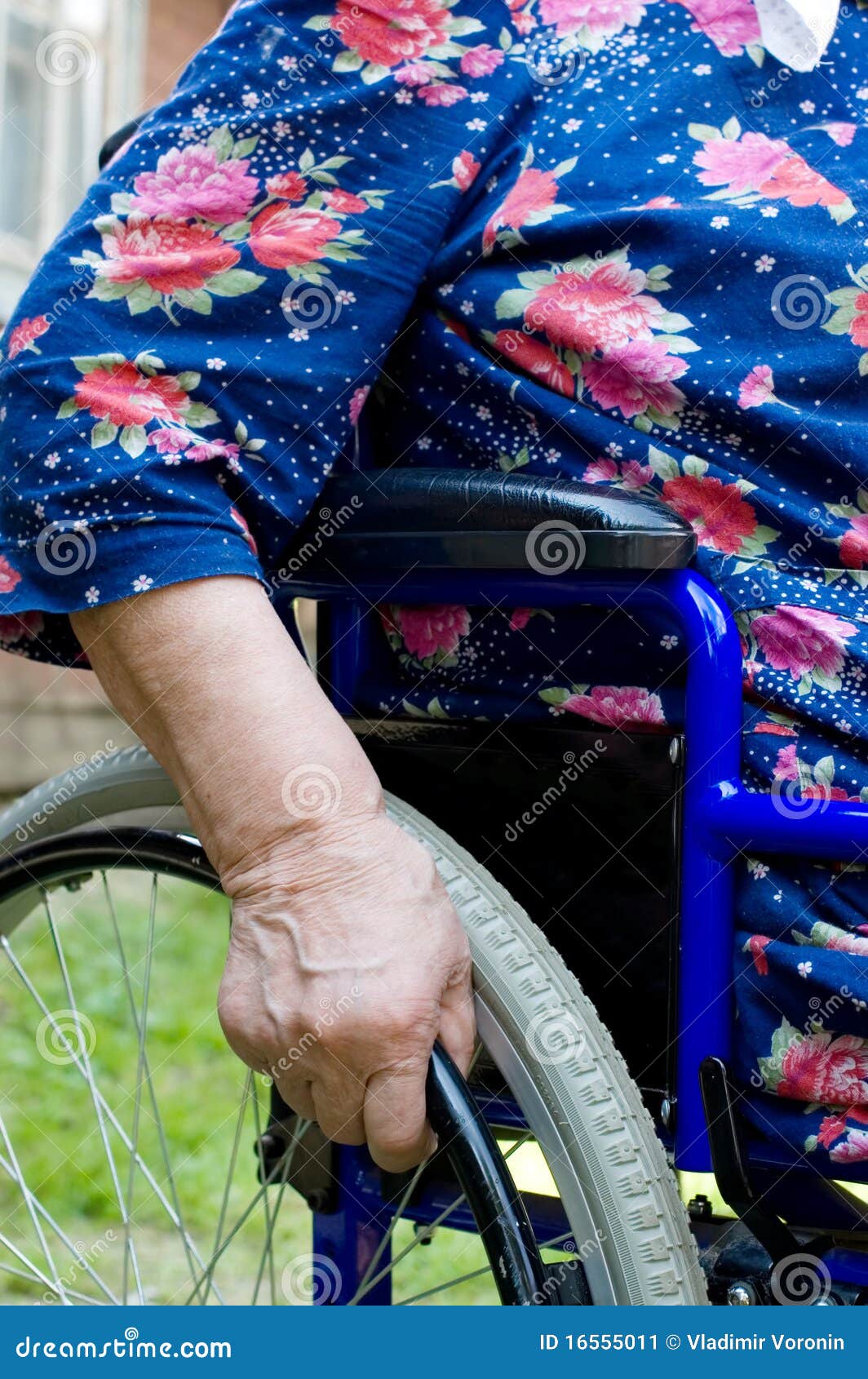hand of the old woman on an invalid armchair