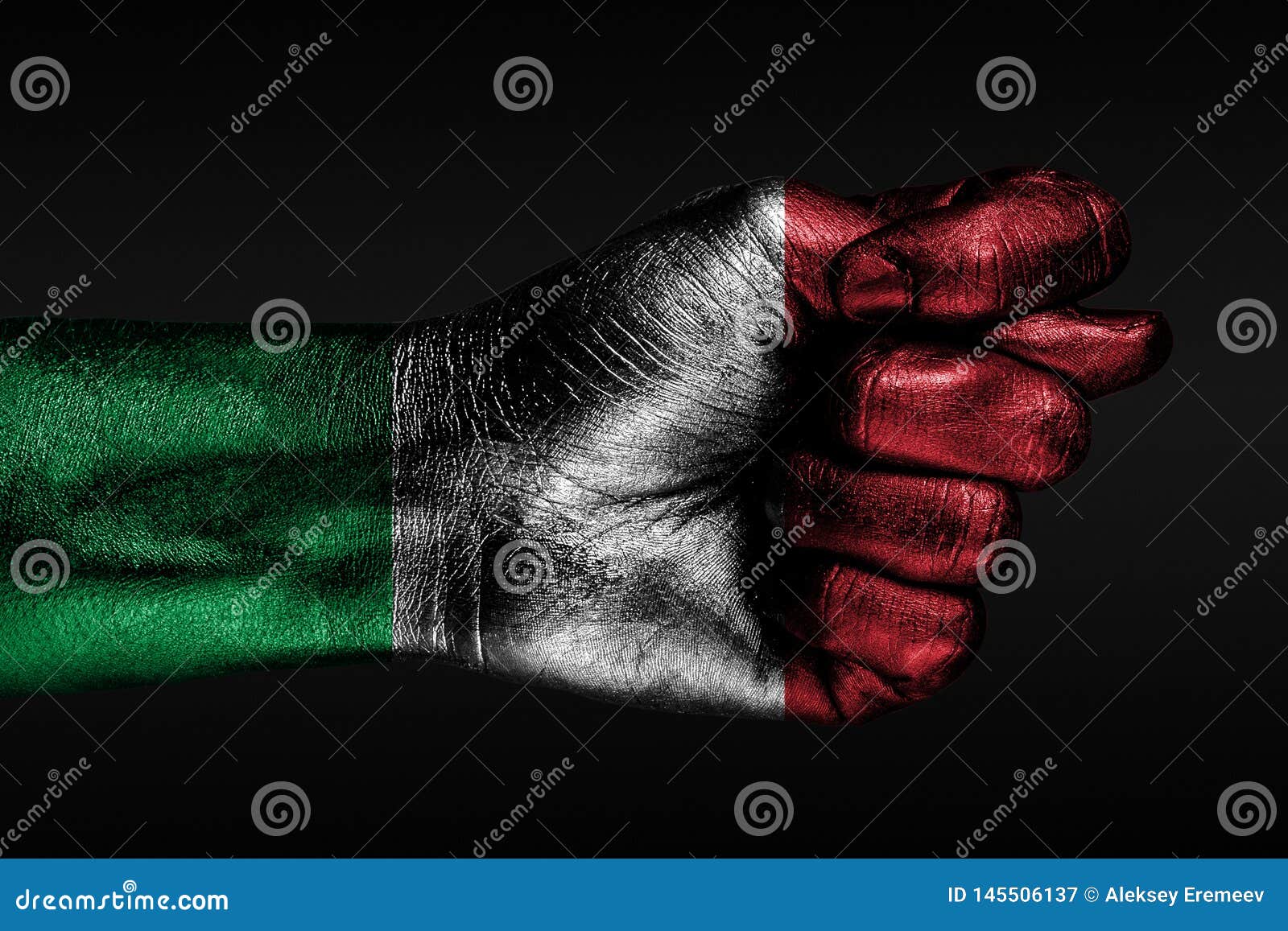 A hand with a painted Italy flag shows a fig, a sign of aggression, disagreement, a dispute on a dark background. Horizontal frame