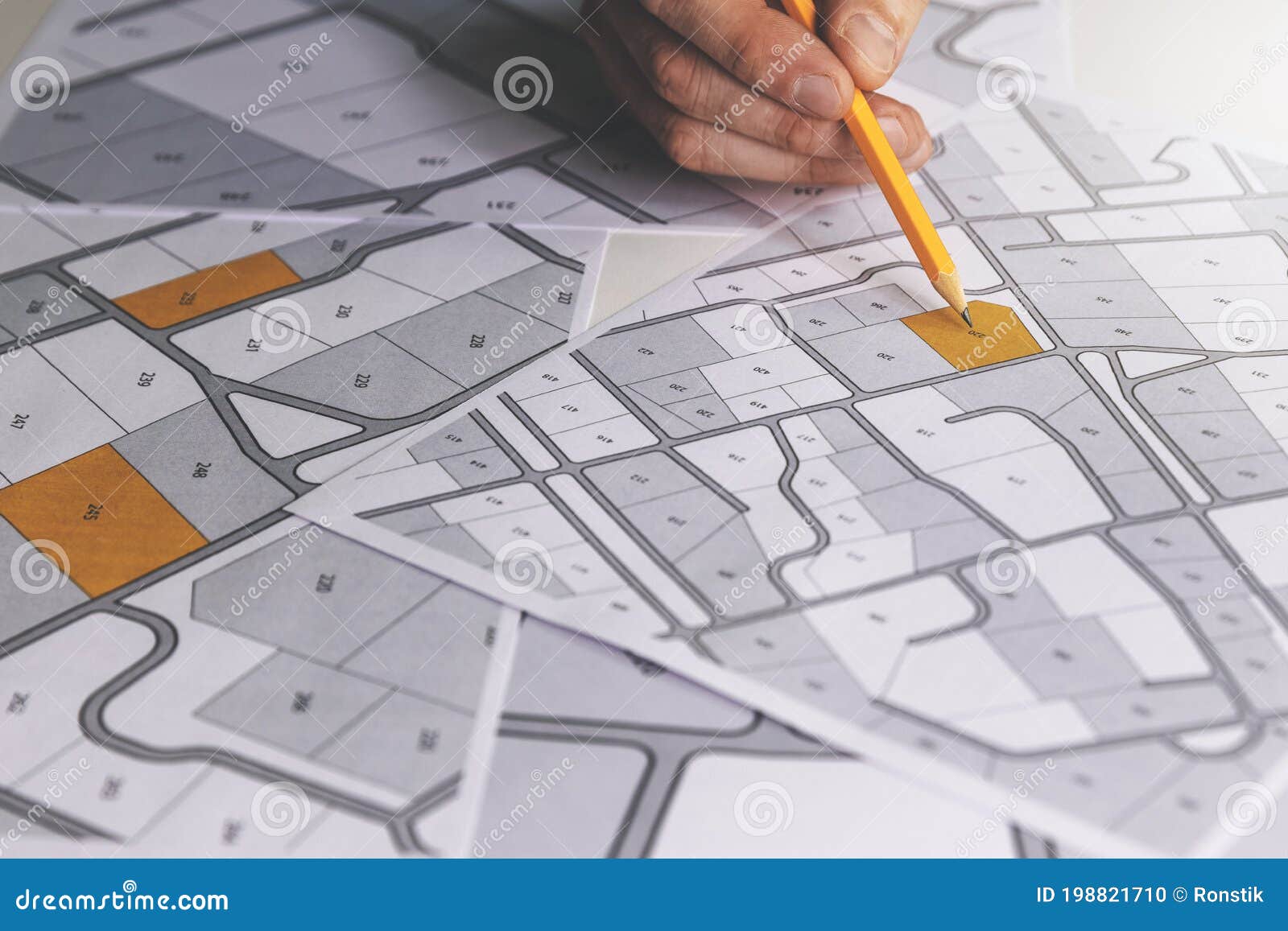 hand with pencil on cadastral map - choose and buy a building plot