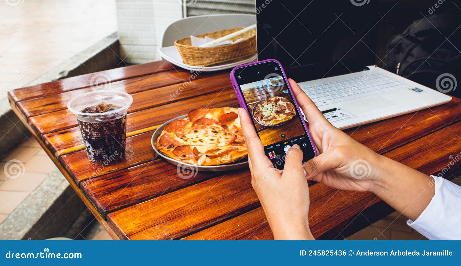 hand of person with mobile photographing food to publish on networks