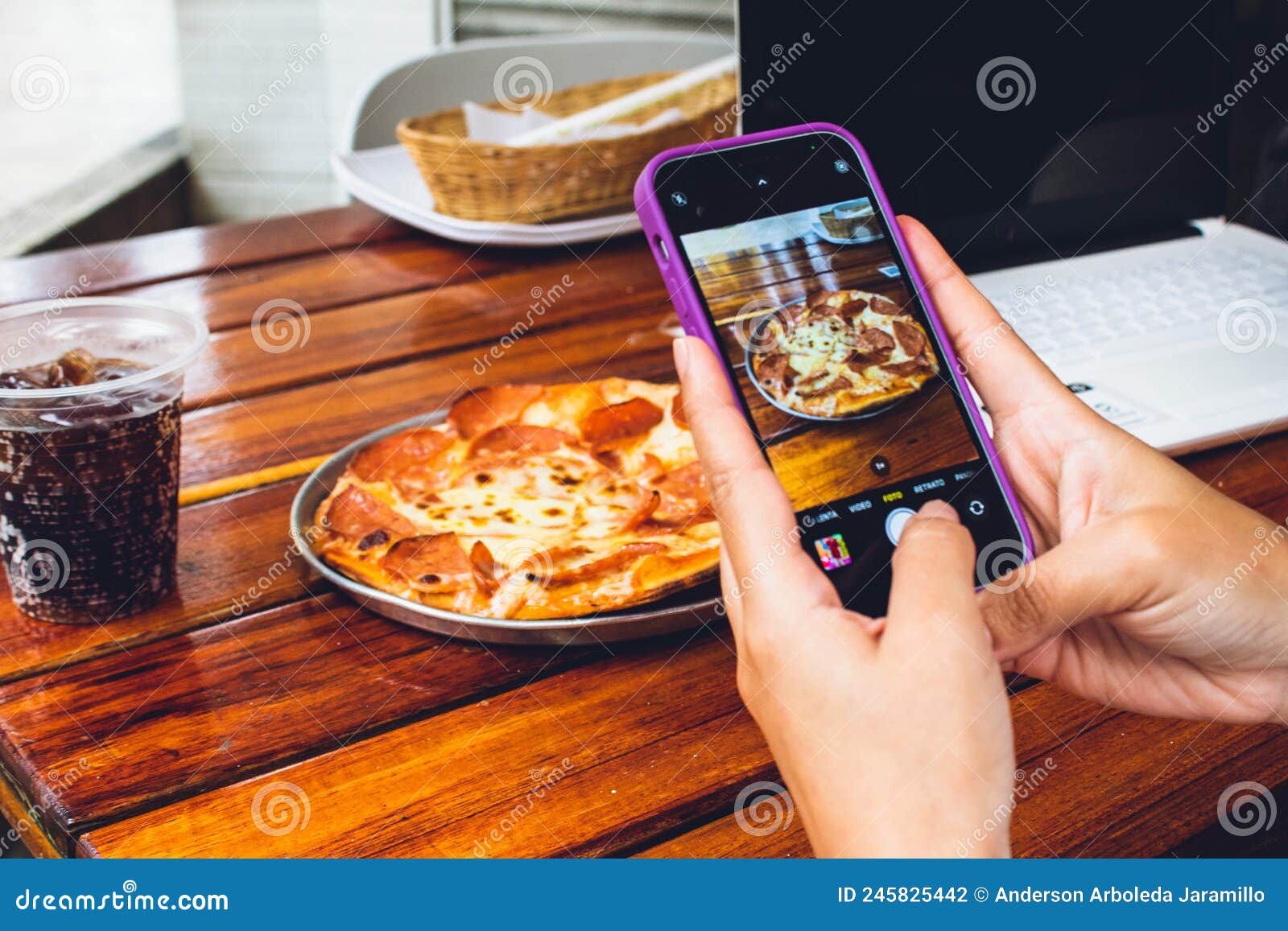 hand of person with mobile photographing food to publish on networks