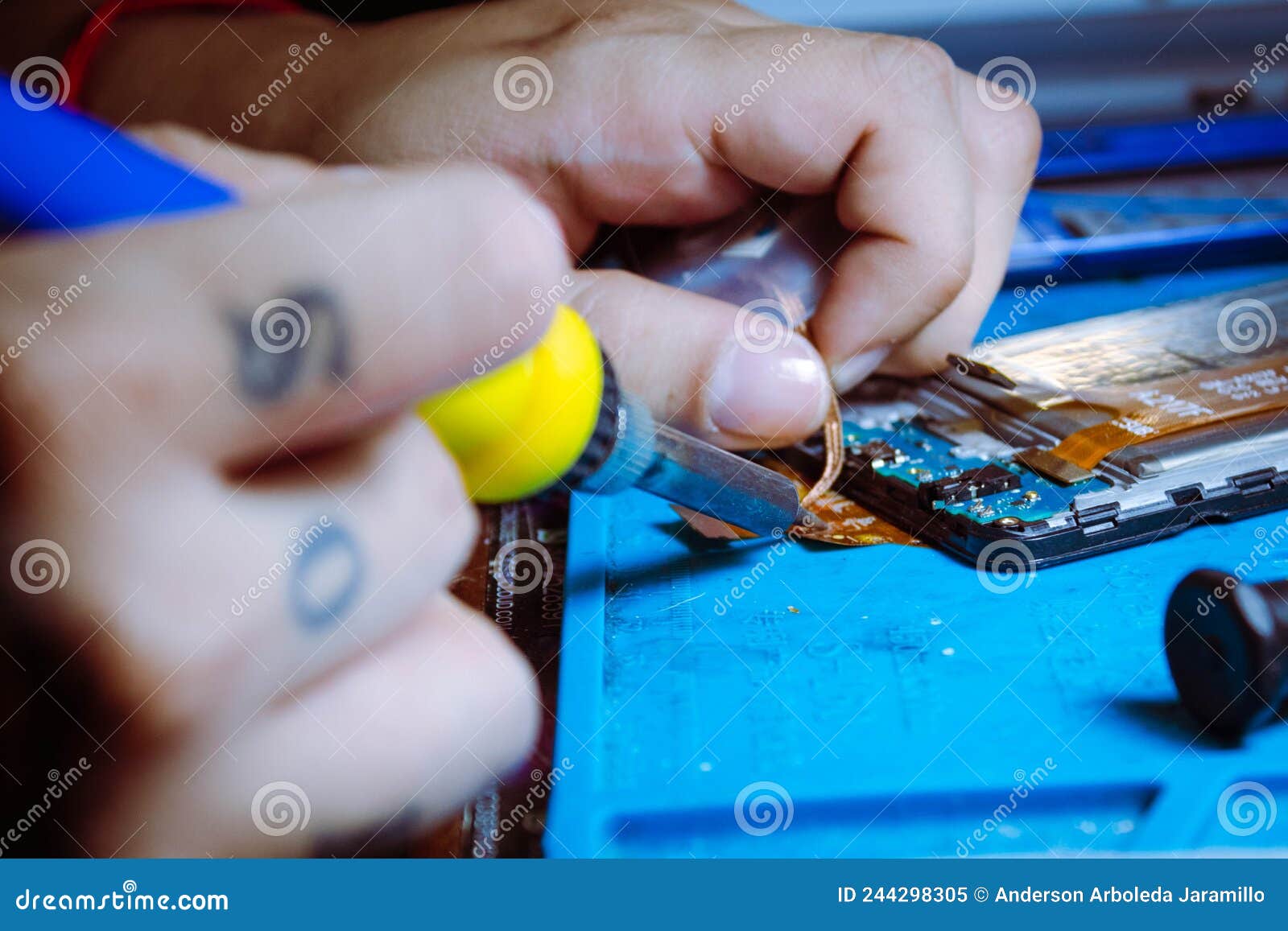 hand of person repairing cell phone inside