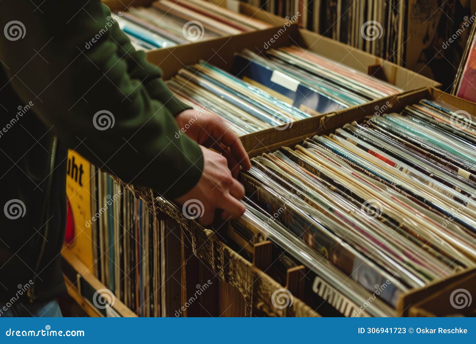 hand picking old vinyl records from a shelf in a book store.