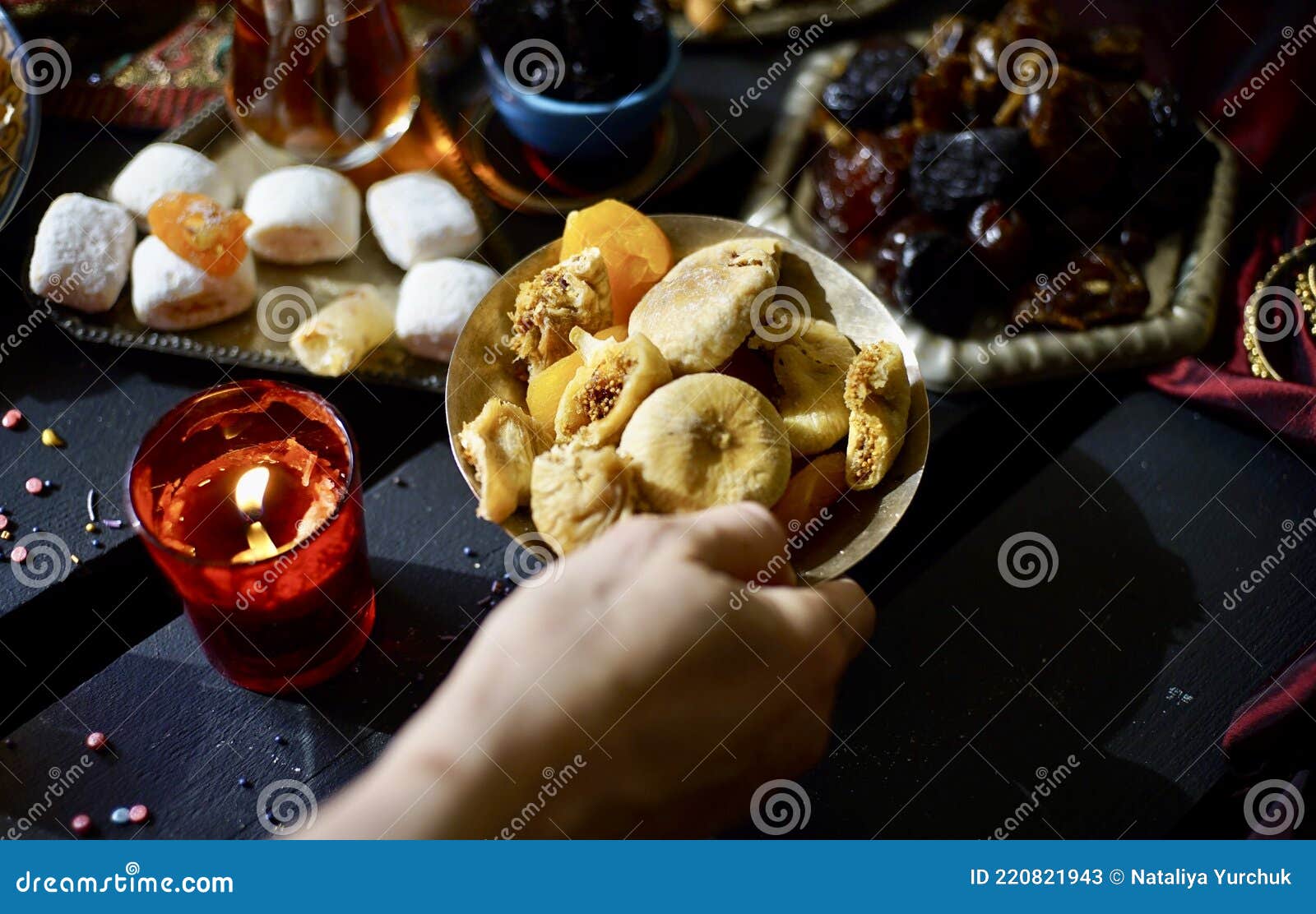 hand with plate with figs as part of eastern sweets table