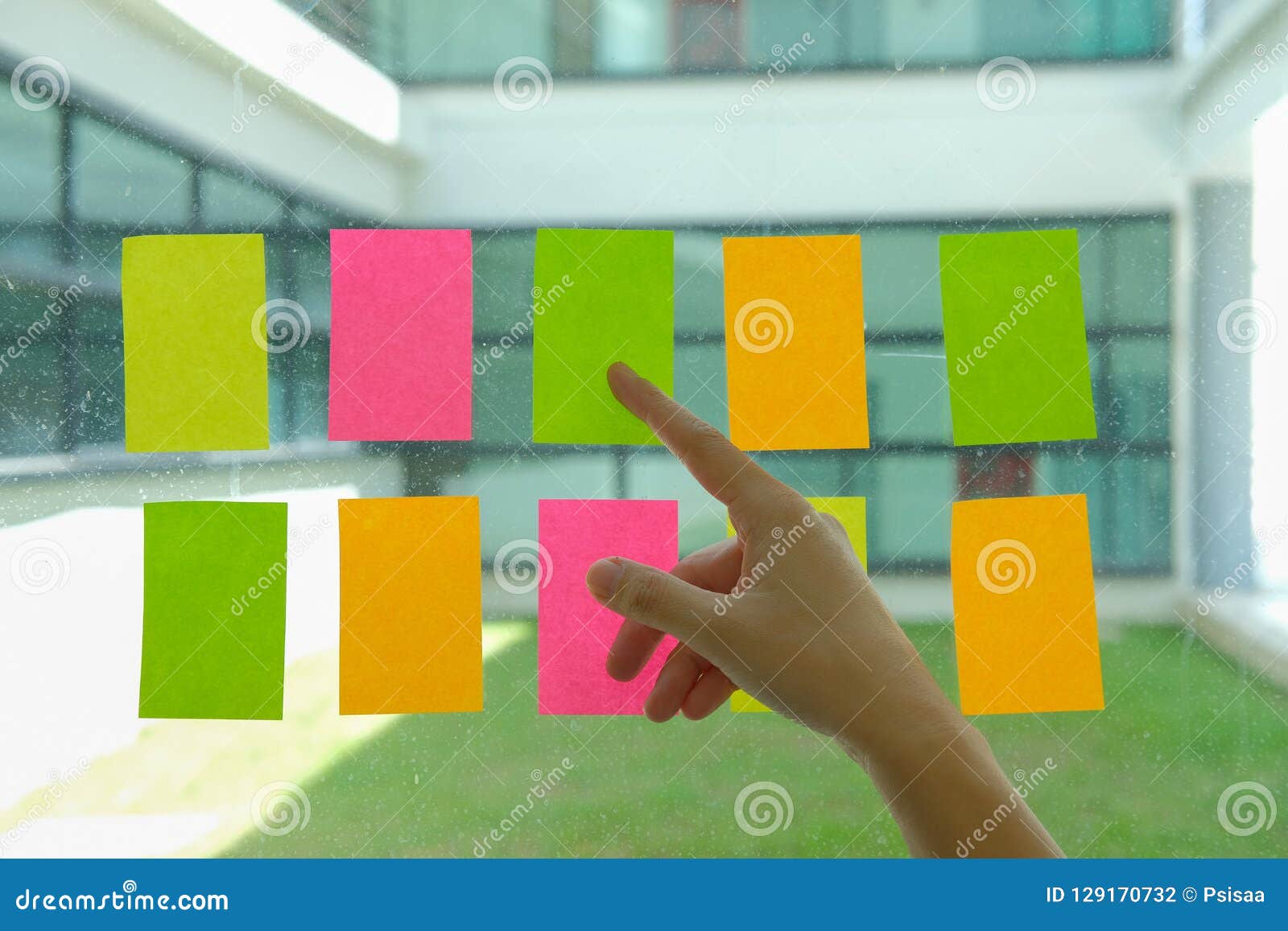 Hand Pointing at Adhesive Notes on Glass Wall. Sticky Note Paper Stock