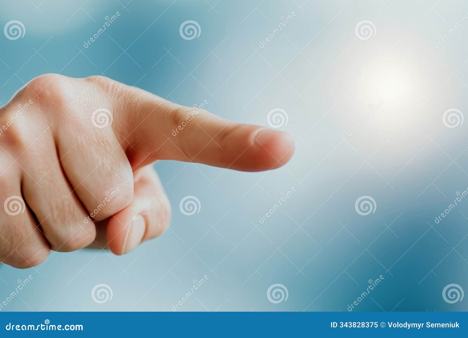 a hand pointing decisively against a soft blurred background at midday in a modern context