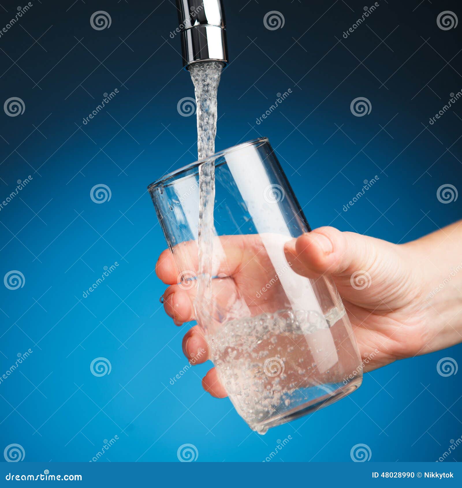 hand pouring a glass of drinking water