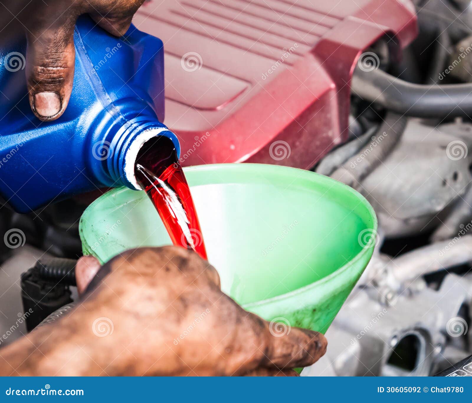 hand pouring transmission fluid through funnel