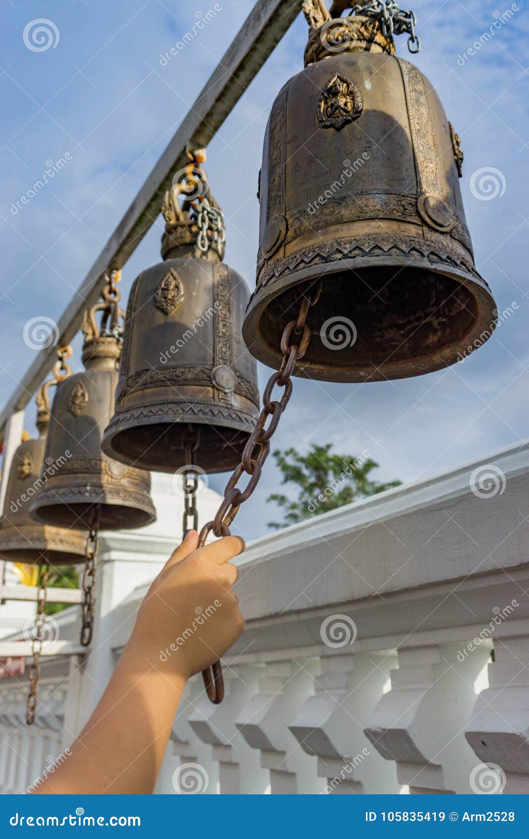 Malaysia, Hand of woman ringing small bell inside temple stock photo