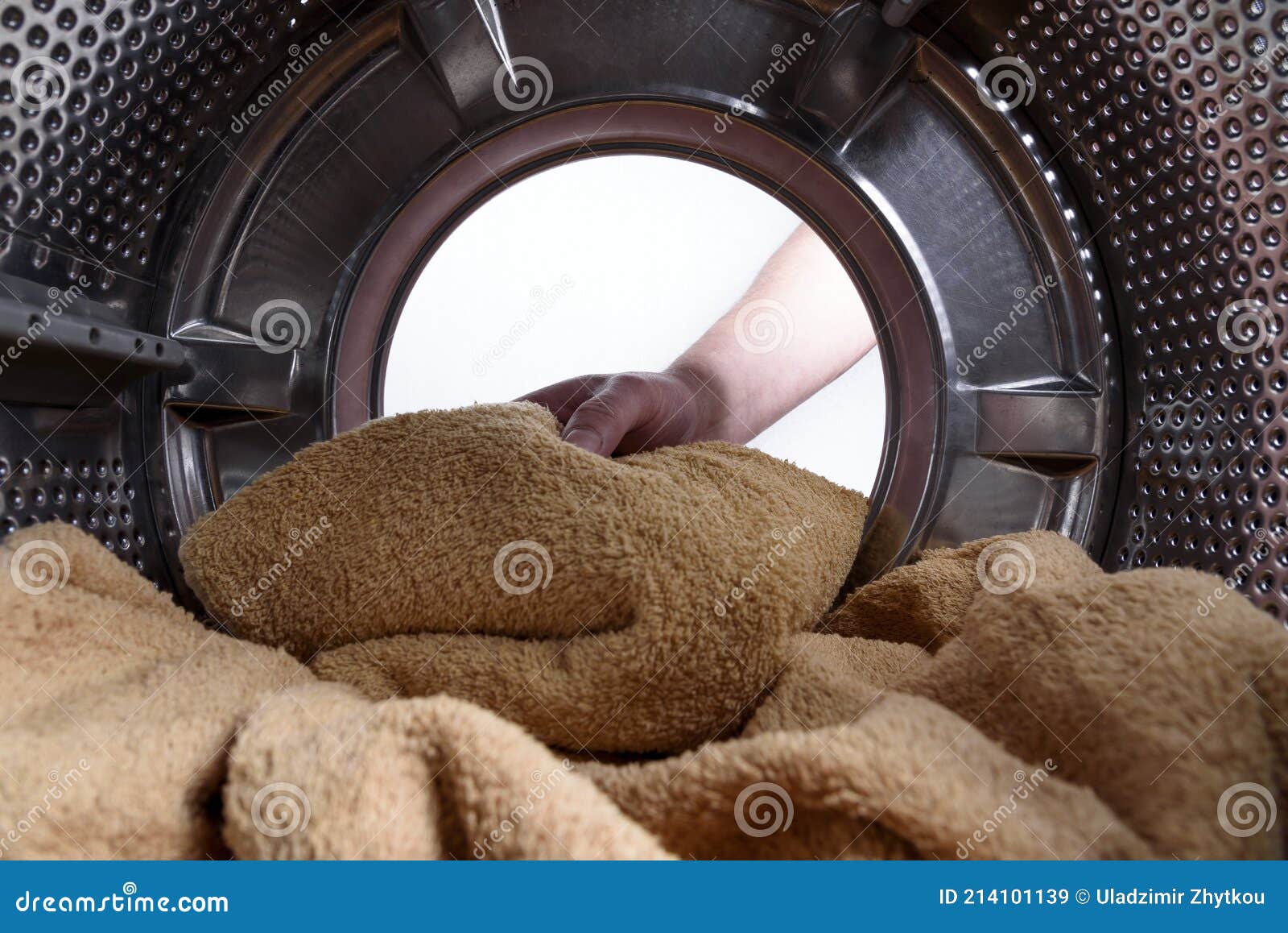 A Hand Pulls Clean Laundry Out of the Washing Machine. View from the