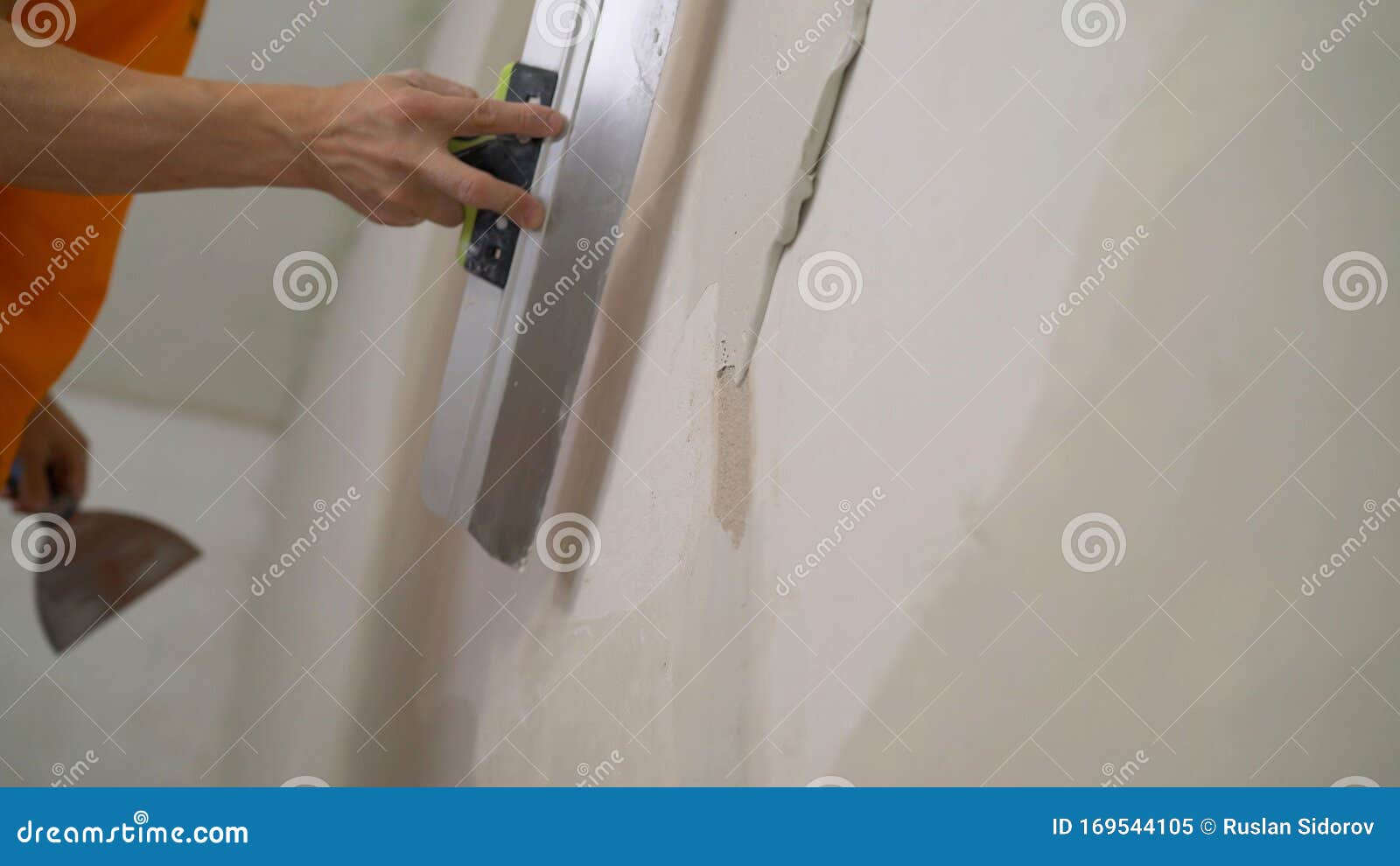 the worker processes the wall with putty. hand with putty knife repair wall, hand with a spatula, spatula with spackle paste