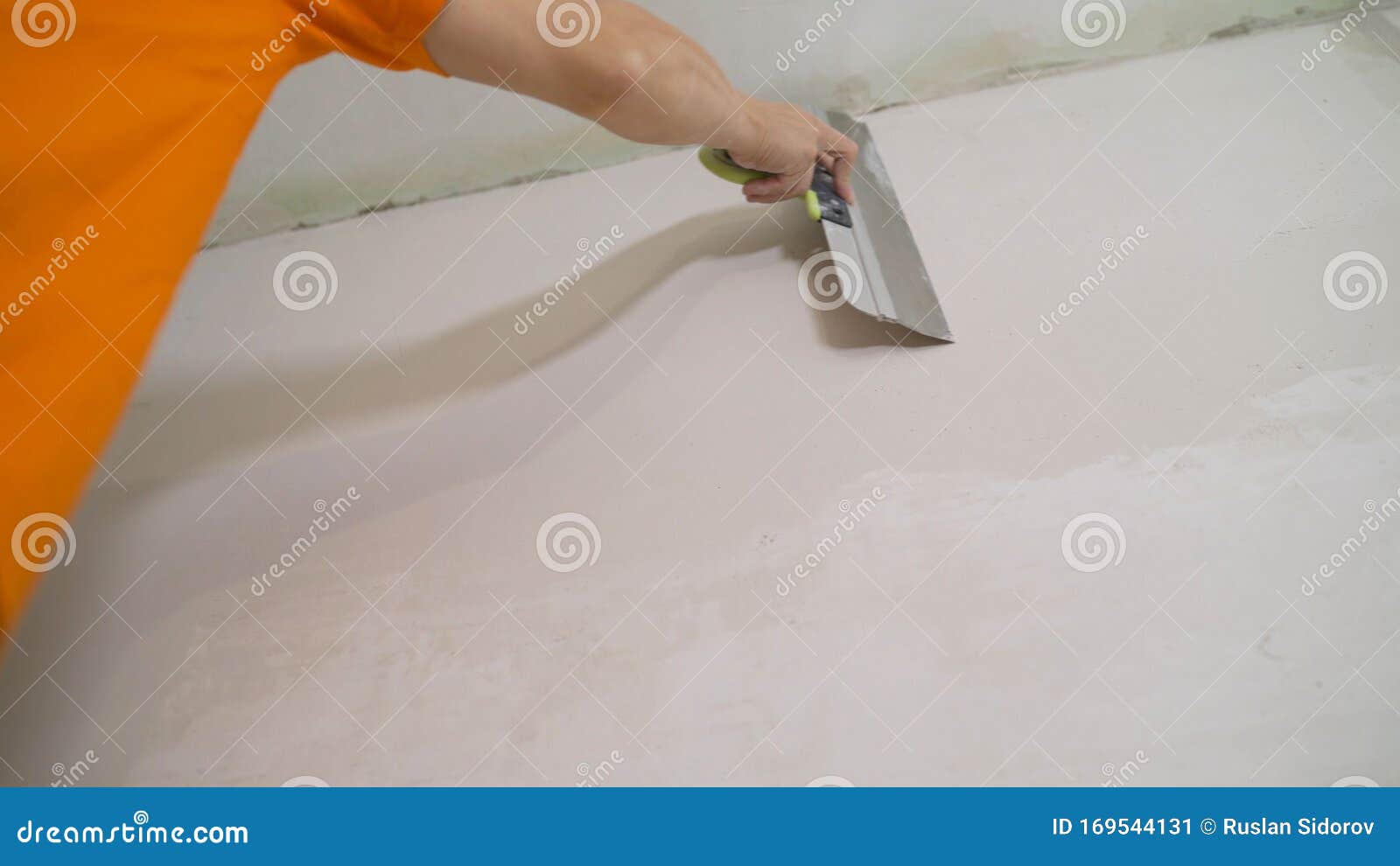 The Worker Processes the Wall with Putty. Hand with Putty Knife Repair