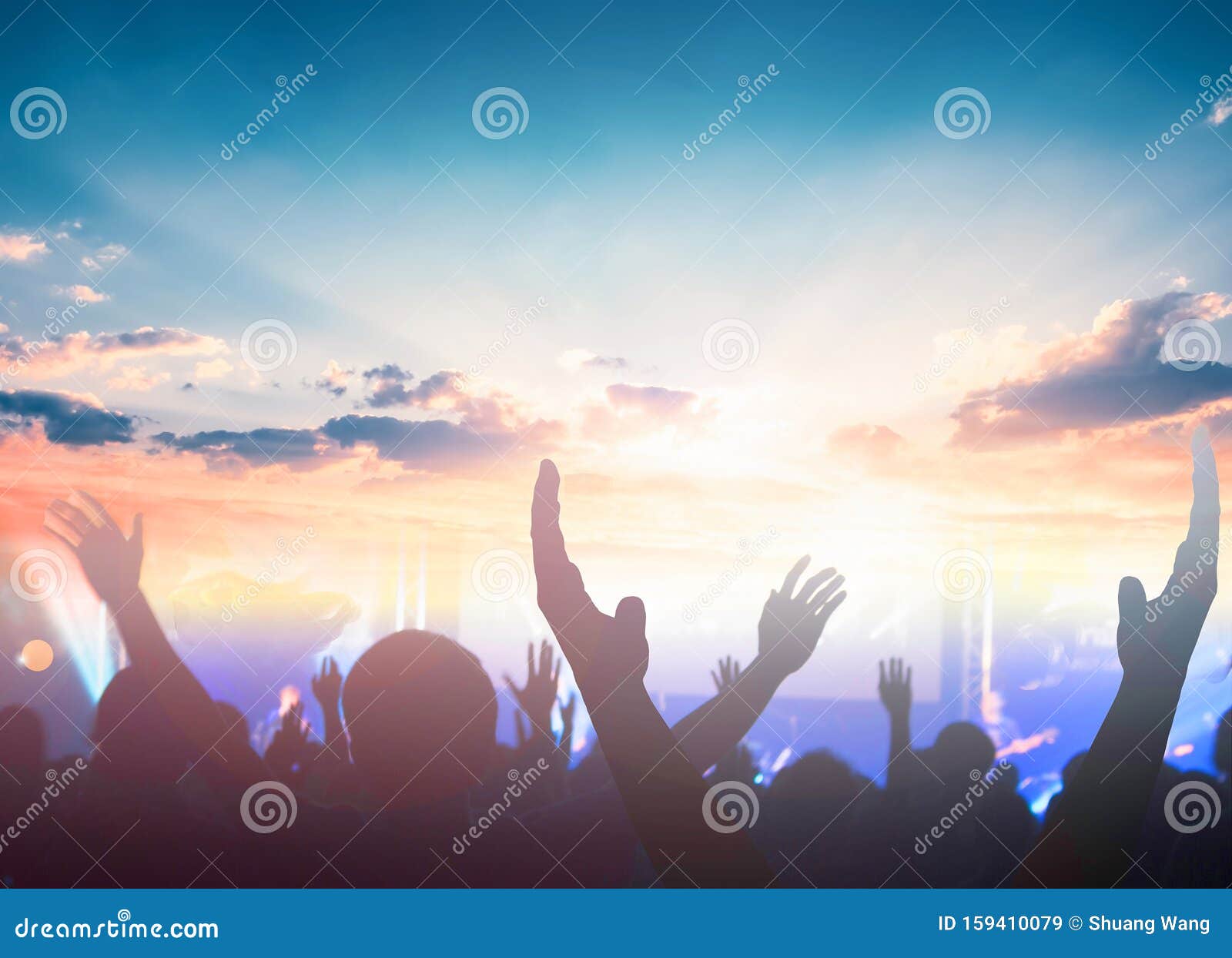 worship and praise concept: christian people hand rising on sunset background