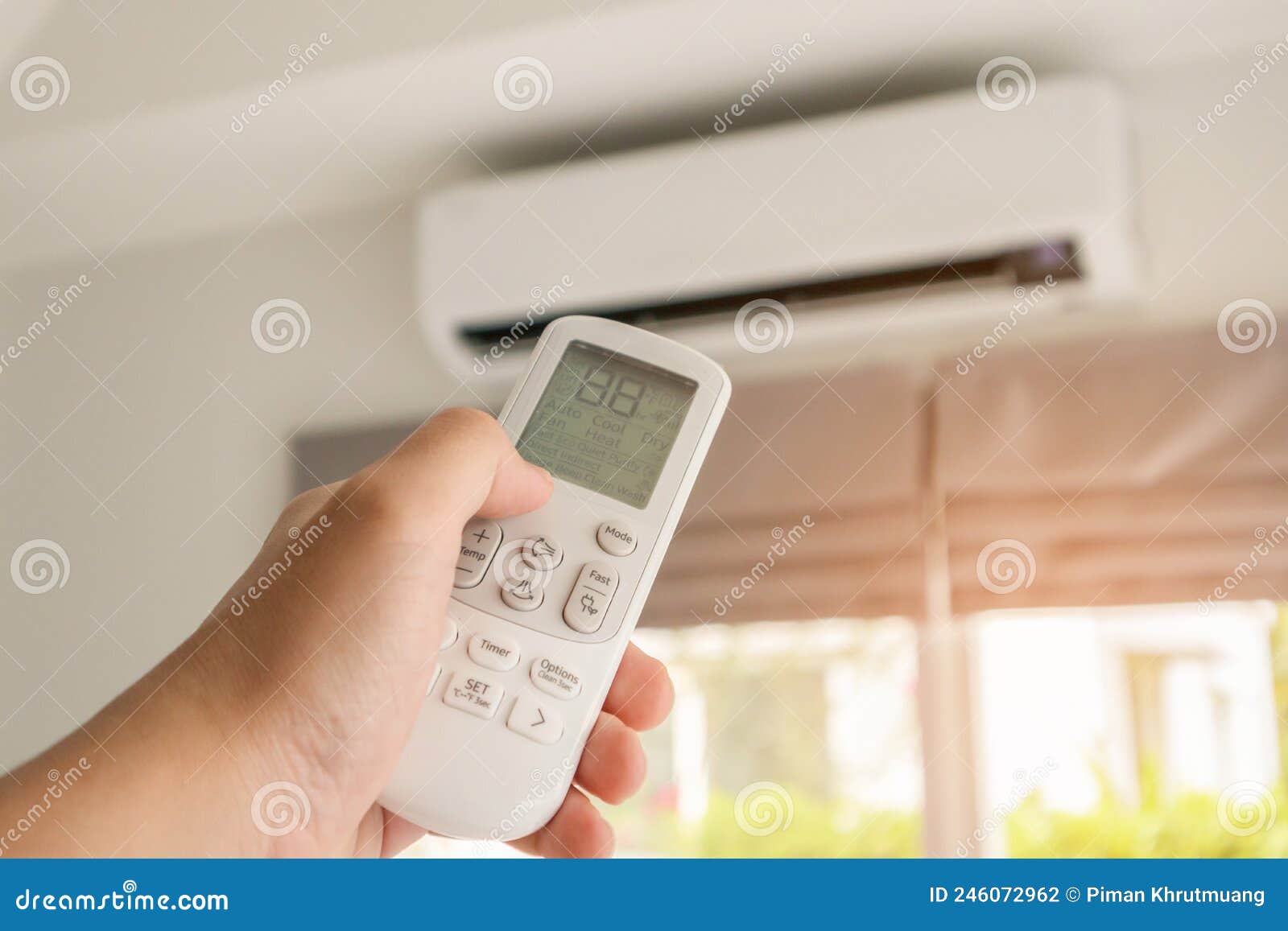Hand with Remote Control Directed on Air Conditioner Stock Photo