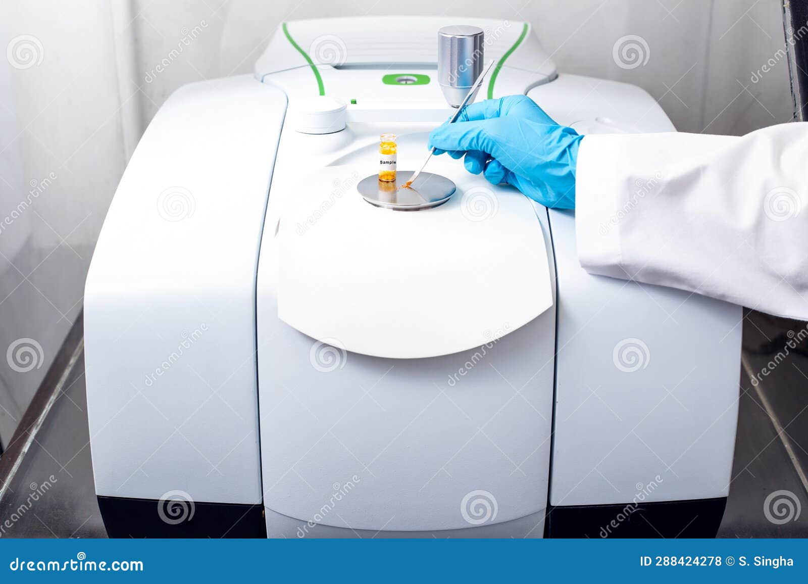 hand of the scientist using a stainless spatula to scoop sample solid from vial to sample analysis and chemical characterization