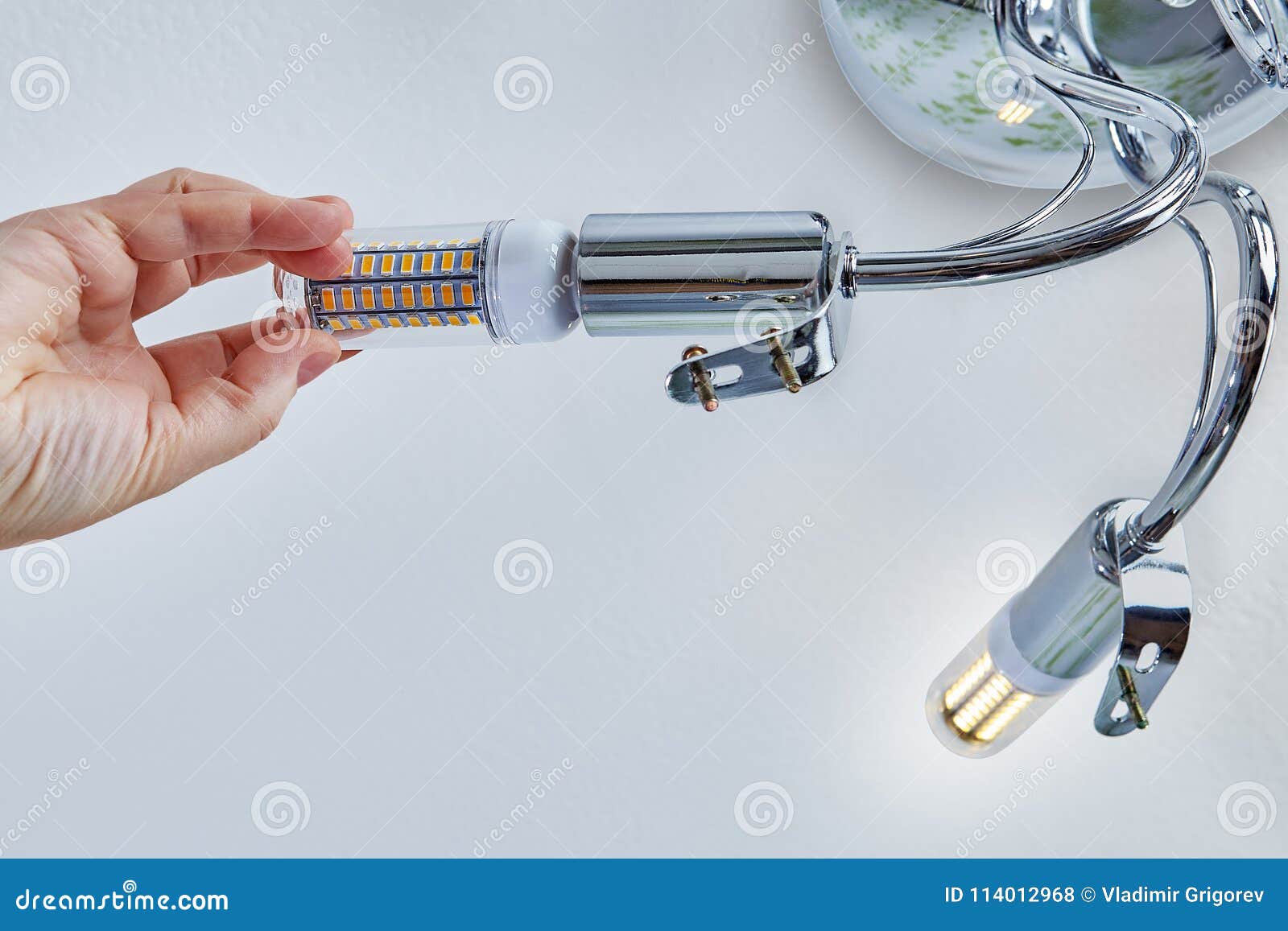 Hand Is Screwing Led Corn Lamp Into Ceiling Chandelier