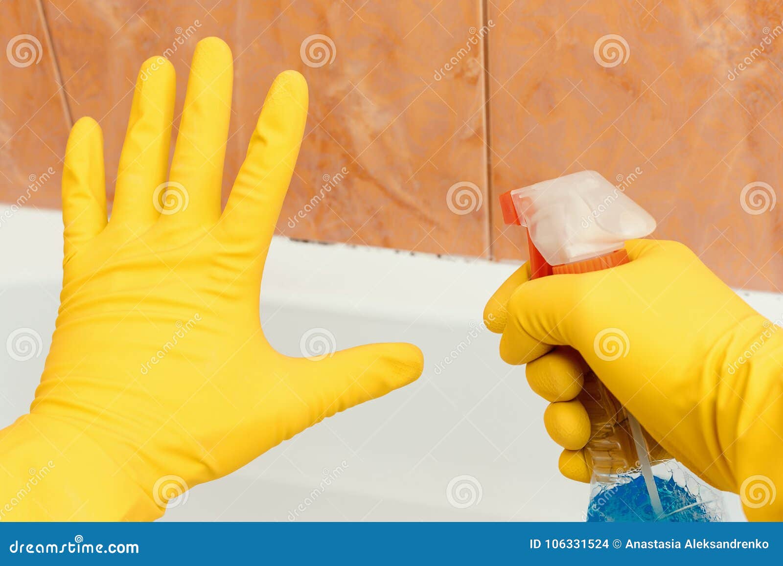 hand showing stop mold in bathroom, the other hand holding a spray tool.