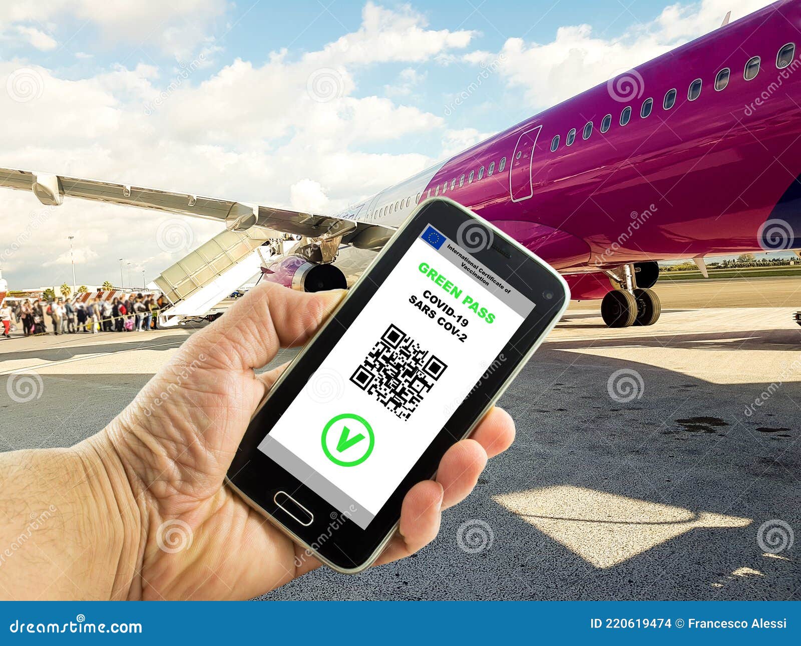 hand with a smartphone with the digital green pass of the european union and the qr code near plane boarding