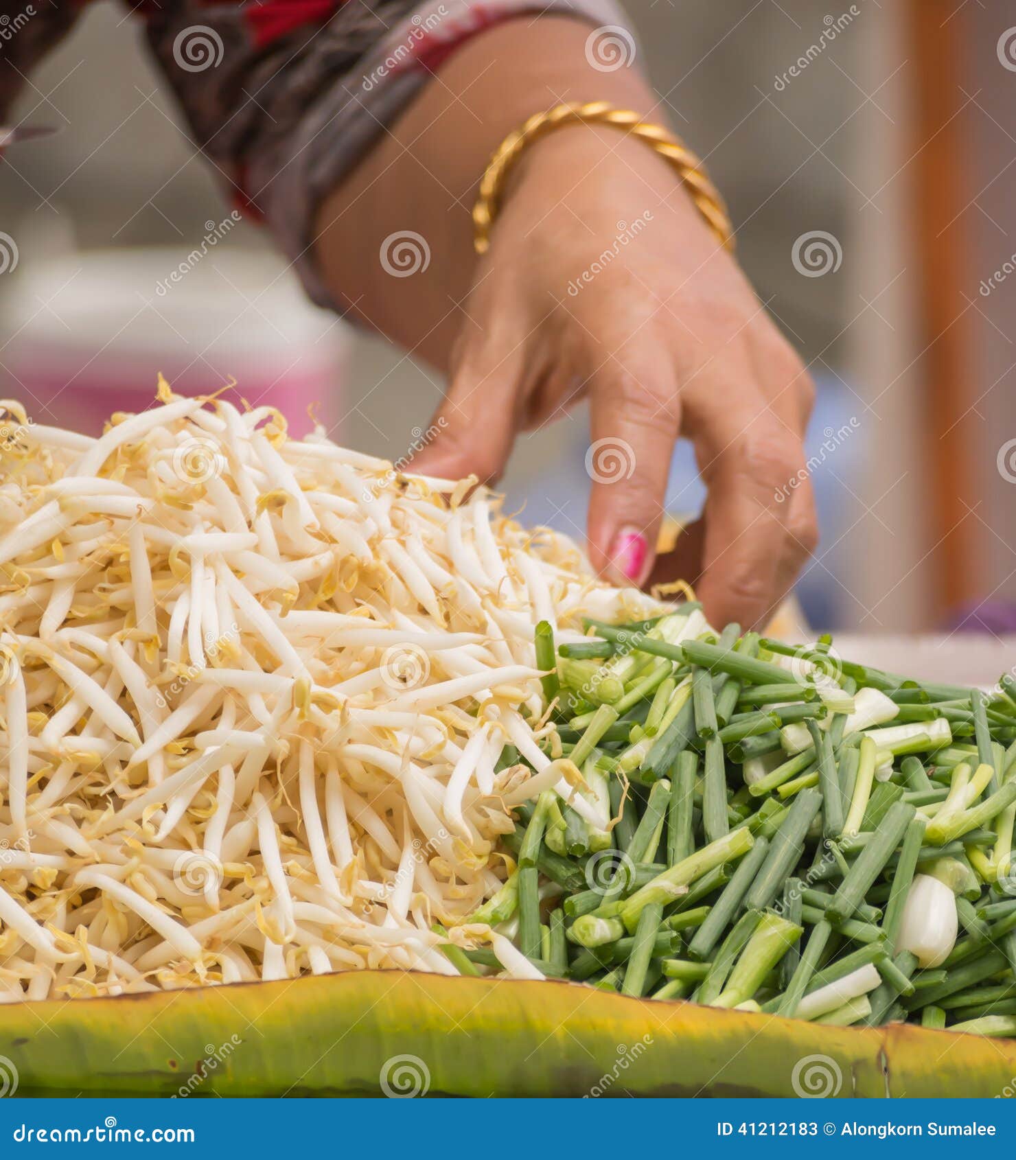 hand of street vender preparing bean sprouts and scallion for pa