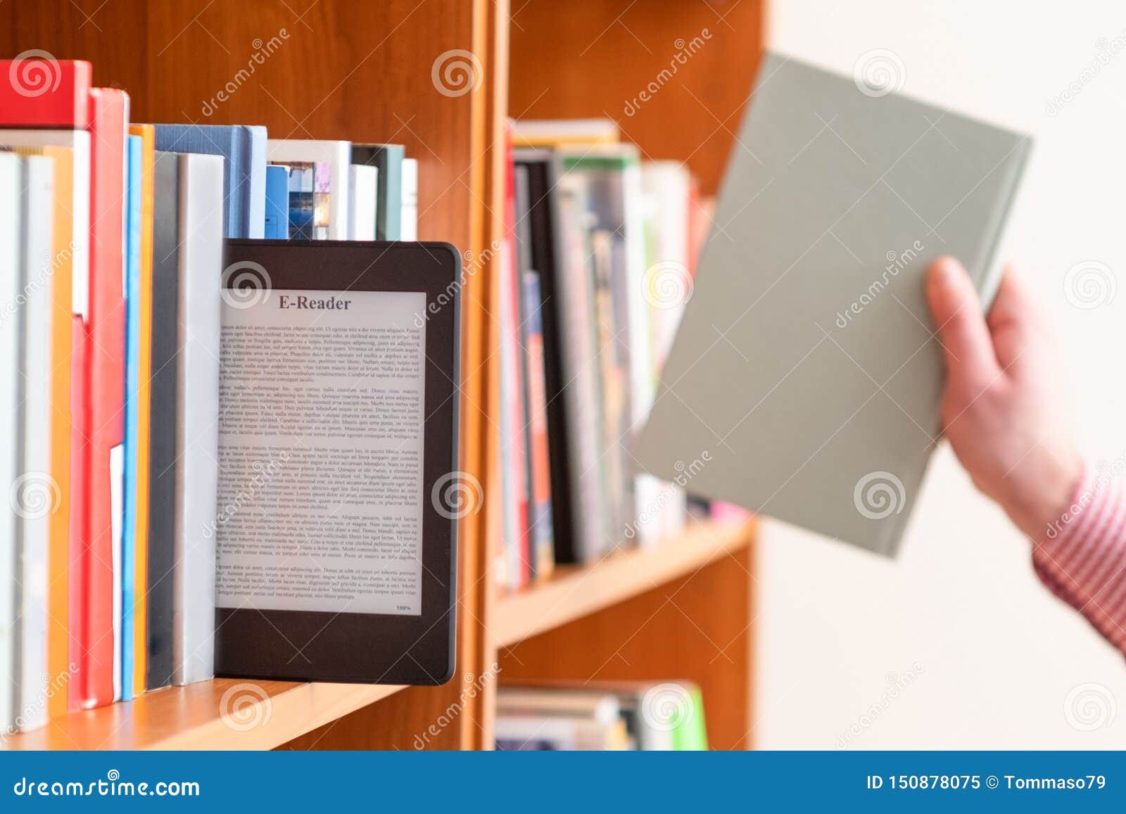 Hand Of Student Keeping Digital Tablet In Bookshelf In School