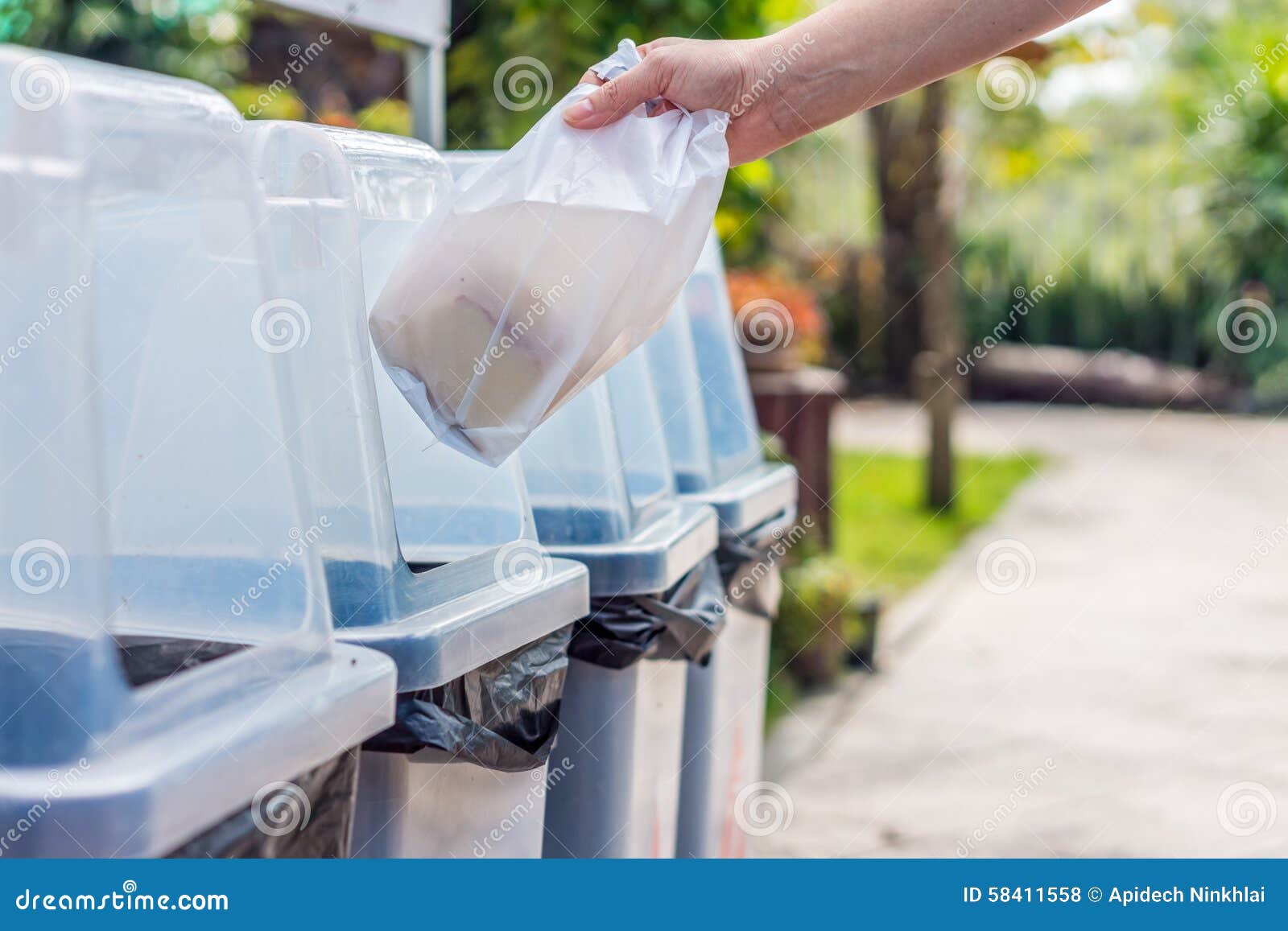 Hand Throws Away Waste Material into Trash Container Stock Photo