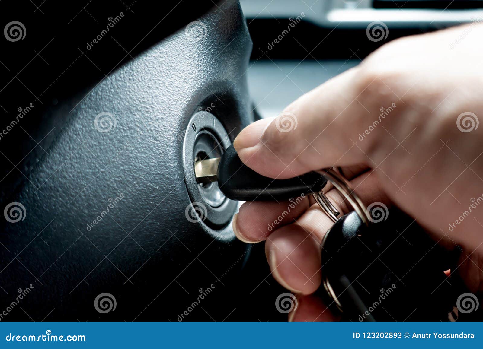 turning car key in the key hole to start the car engine