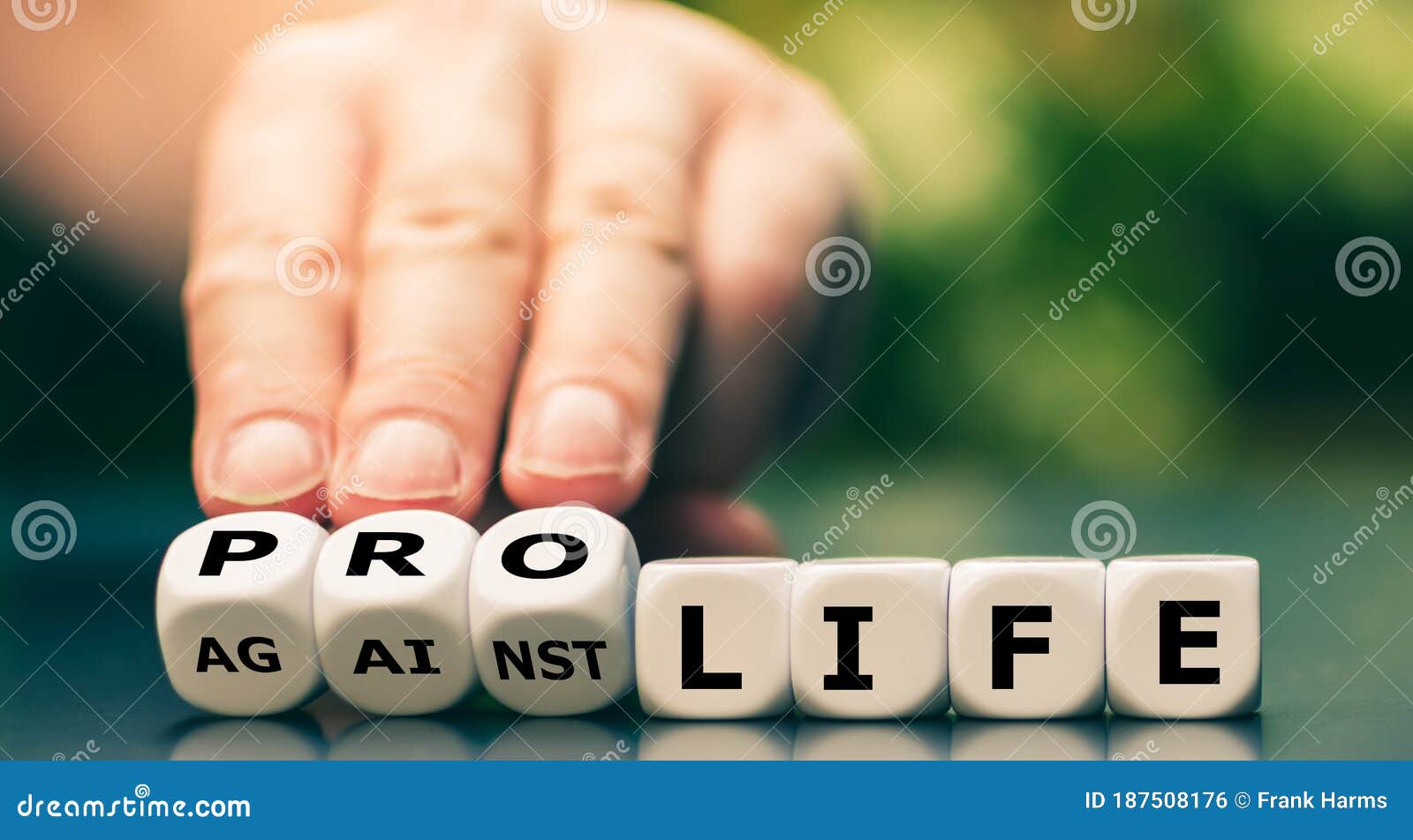 hand turns dice and changes the expression `against life` to `pro life`.