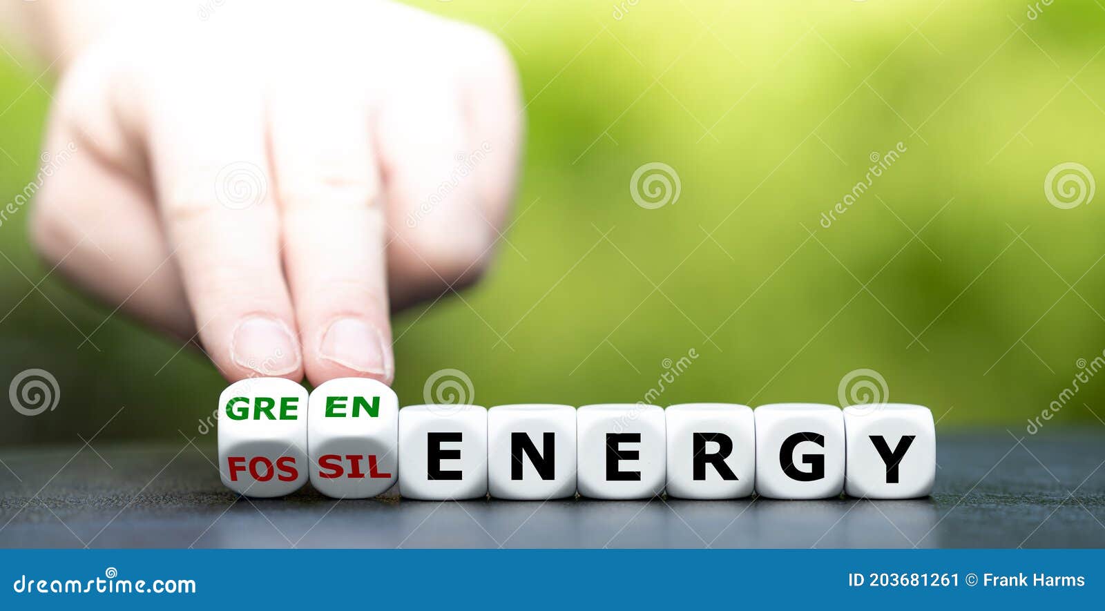 hand turns dice and changes the expression `fossil energy` to `green energy`.